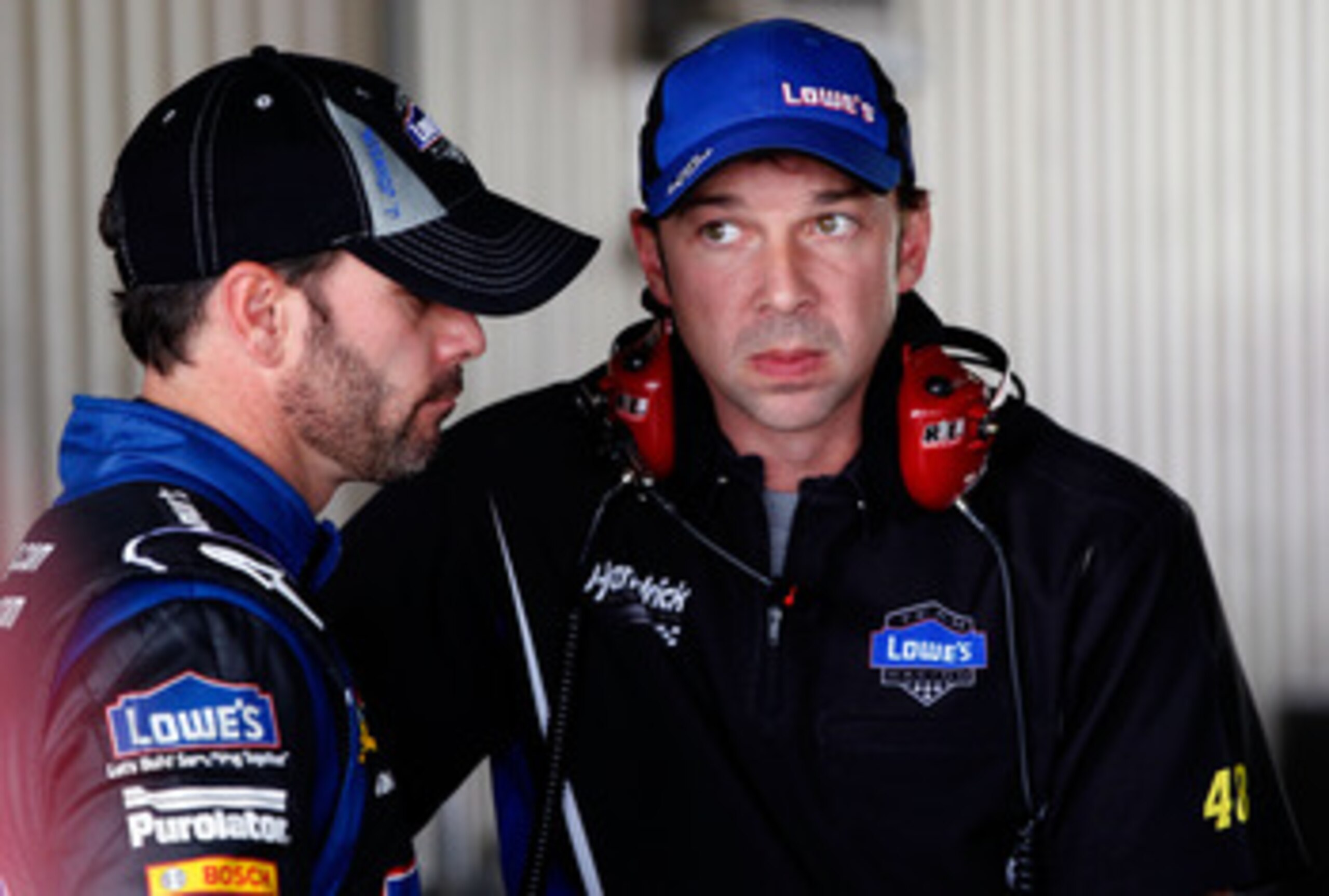 DOVER, DE - MAY 13: Jimmie Johnson (L), driver of the #48 Lowe's Chevrolet, talks with crew chief Chad Knaus (R) in the garage during practice for the NASCAR Sprint Cup Series FedEx 400 Benefiting Autism Speaks at Dover International Speedway on May 13, 2