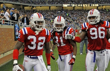 DETROIT - NOVEMBER 25:  Devin McCourty #32 of the New England Patriots celebrates his interception with teammates Brandon Meriweather #31 and Jermaine Cunningham #96 during the fourth quarter of the game against the Detroit Lions at Ford Field on November