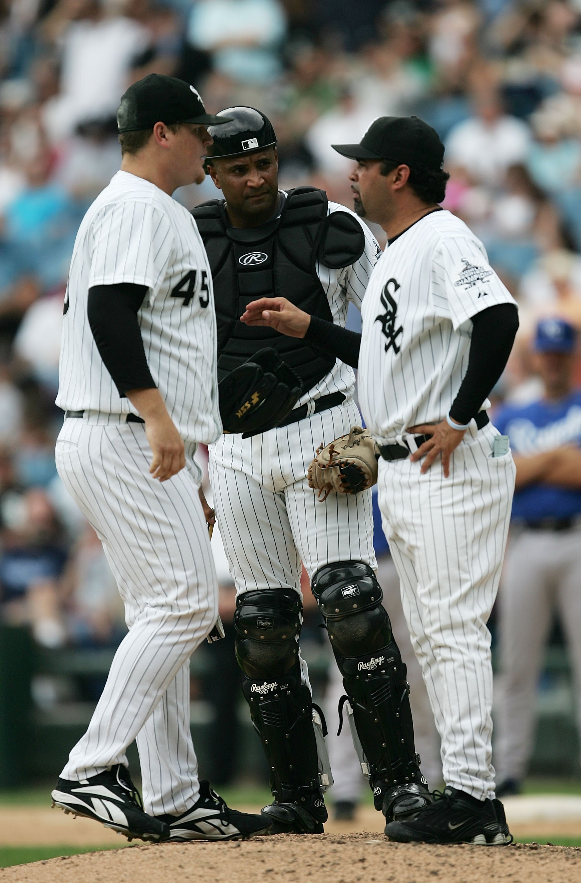 CHICAGO - AUGUST 17:  Manager Ozzie Guillen #13 of the Chicago White Sox (R) talks with catcher Sandy Alomar, Jr. #26 and closer Bobby Jenks #45 in the eighth inning of a game against the Kansas City Royals August 17, 2006 at U.S. Cellular Field in Chicag