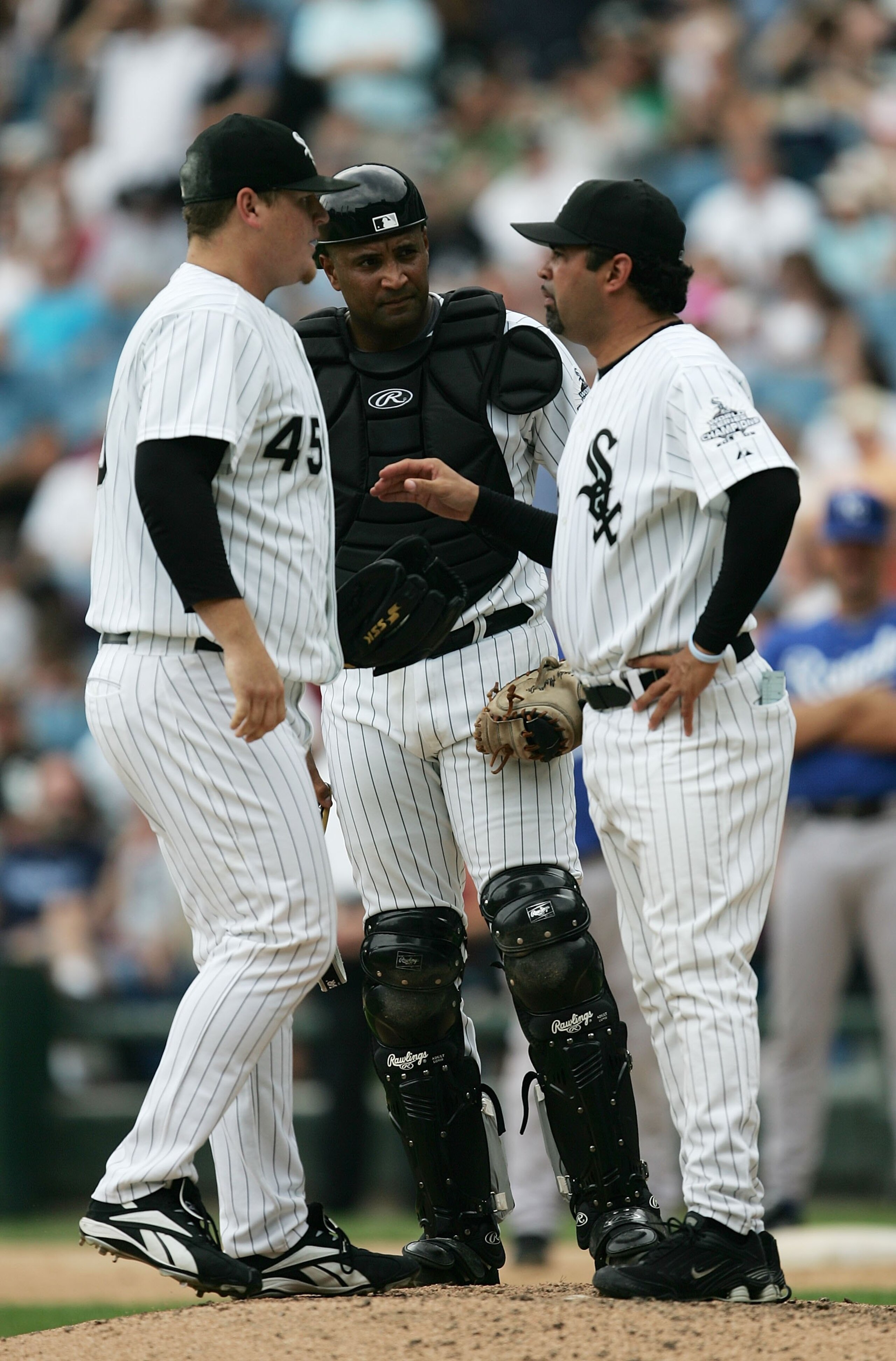 CHICAGO - AUGUST 17:  Manager Ozzie Guillen #13 of the Chicago White Sox (R) talks with catcher Sandy Alomar, Jr. #26 and closer Bobby Jenks #45 in the eighth inning of a game against the Kansas City Royals August 17, 2006 at U.S. Cellular Field in Chicag