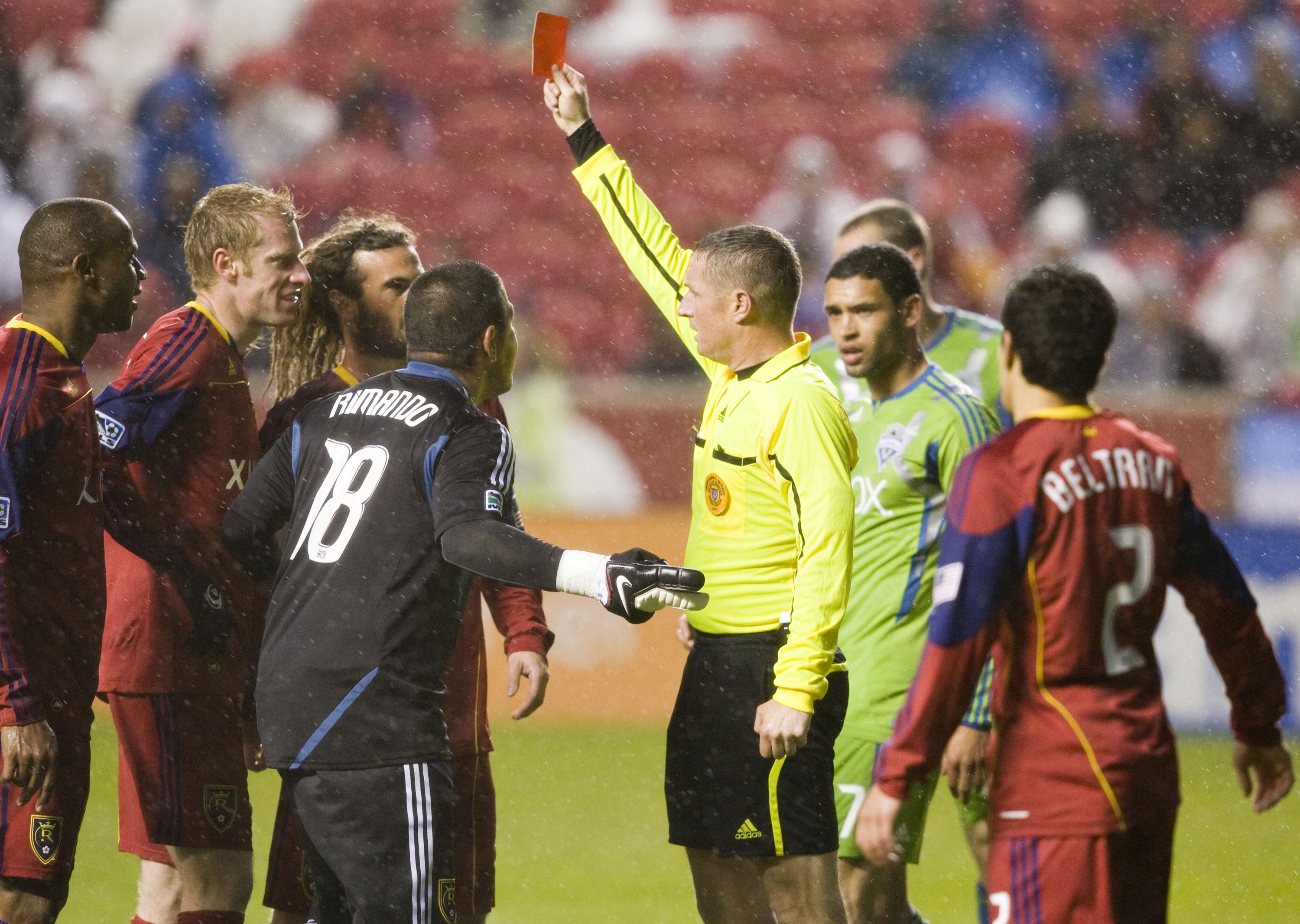 SANDY, UT - MAY 28: Referee Mark Kadlecik holds up a red card for defender Jamison Olave #4 of Real Salt Lake (L) after obstructing Mike Futico #2 of the Seattle Sounders FC on a break away deep in goal scoring territory in a MLS soccer game on May 28, 20