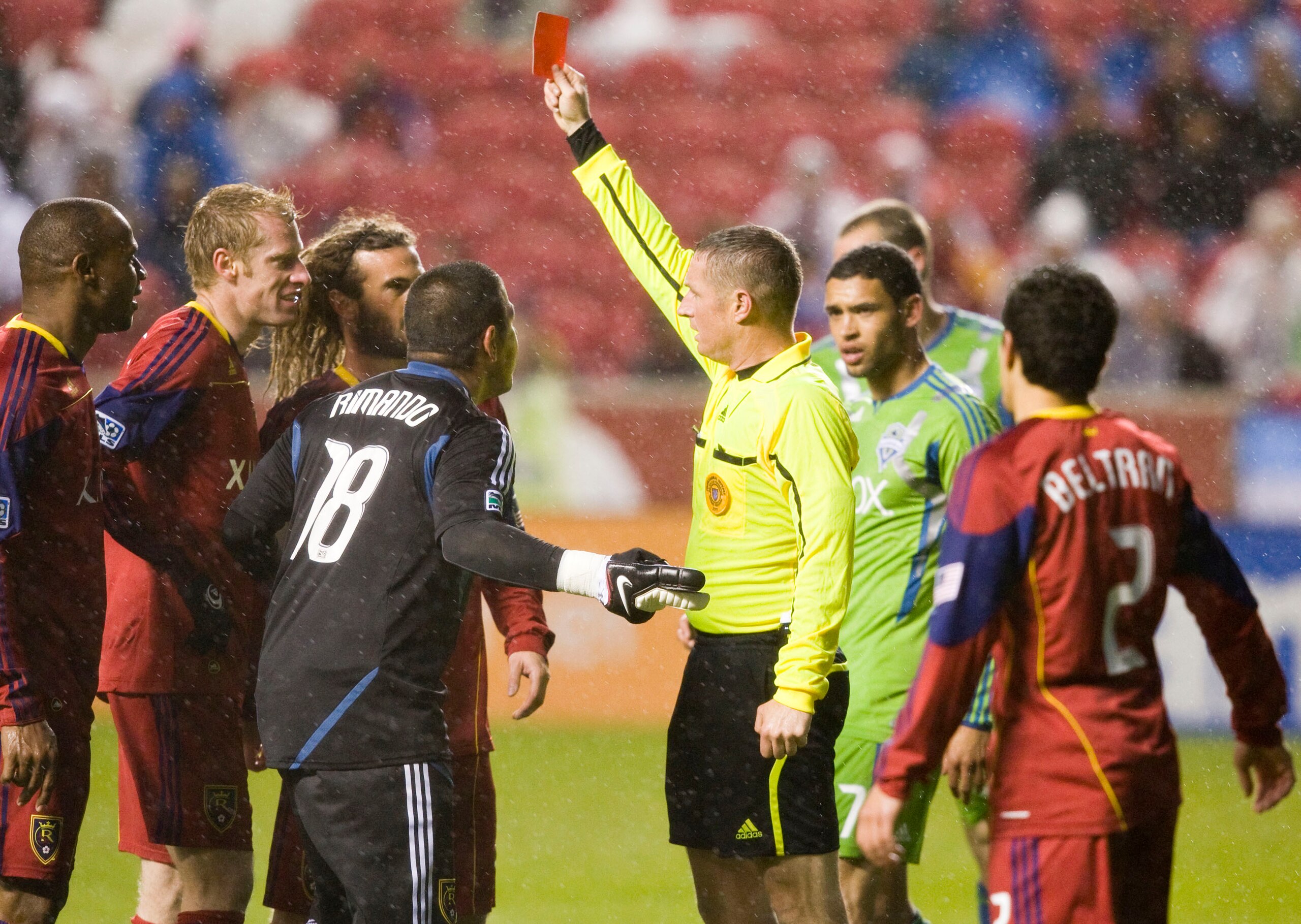 SANDY, UT - MAY 28: Referee Mark Kadlecik holds up a red card for defender Jamison Olave #4 of Real Salt Lake (L) after obstructing Mike Futico #2 of the Seattle Sounders FC on a break away deep in goal scoring territory in a MLS soccer game on May 28, 20