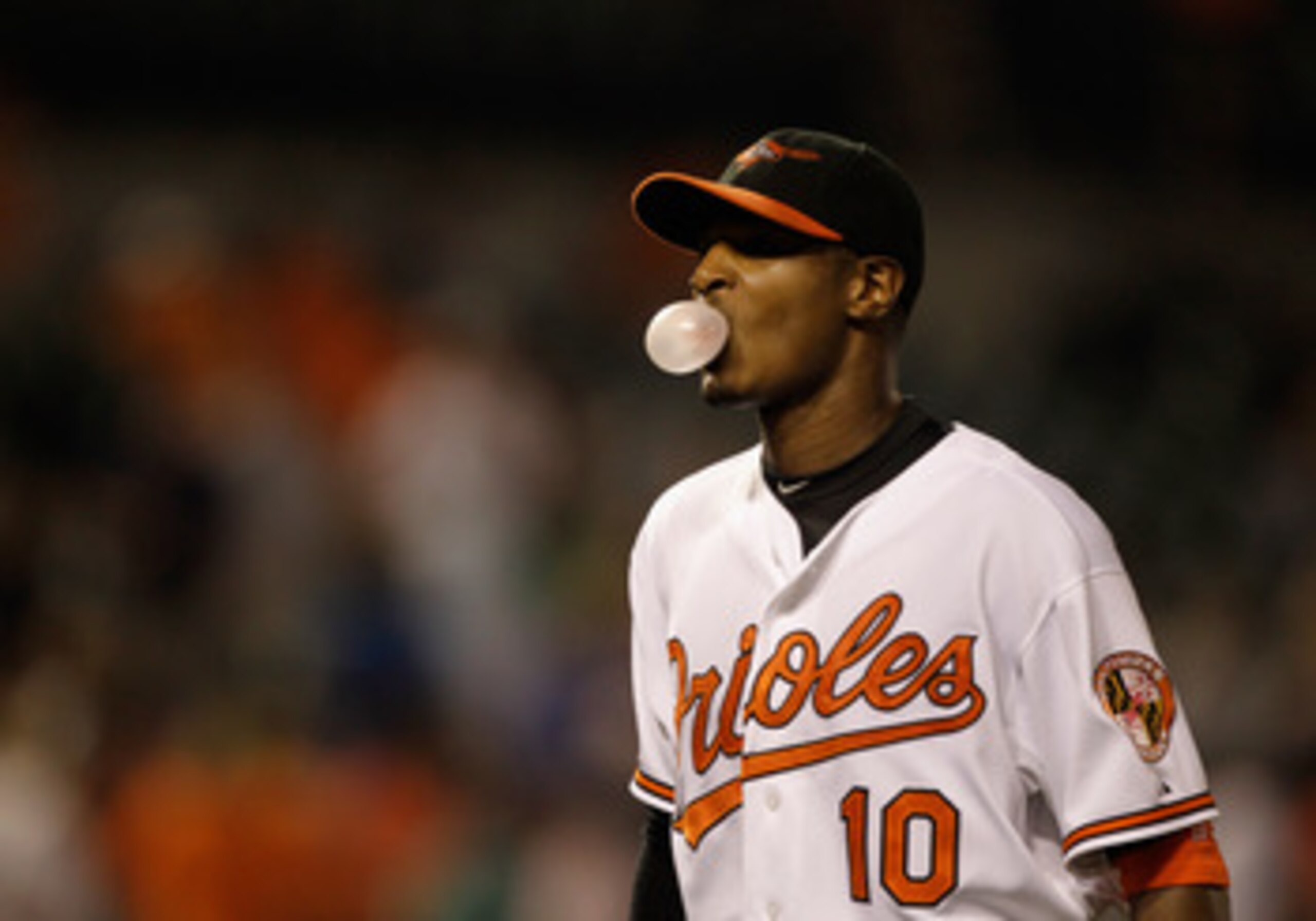 BALTIMORE, MD - MAY 25: Adam Jones #10 of the Baltimore Orioles blows a bubble while walking off the field after the Orioles defeated the Kansas City Royals 9-2 at Oriole Park at Camden Yards on May 25, 2011 in Baltimore, Maryland.  (Photo by Rob Carr/Get