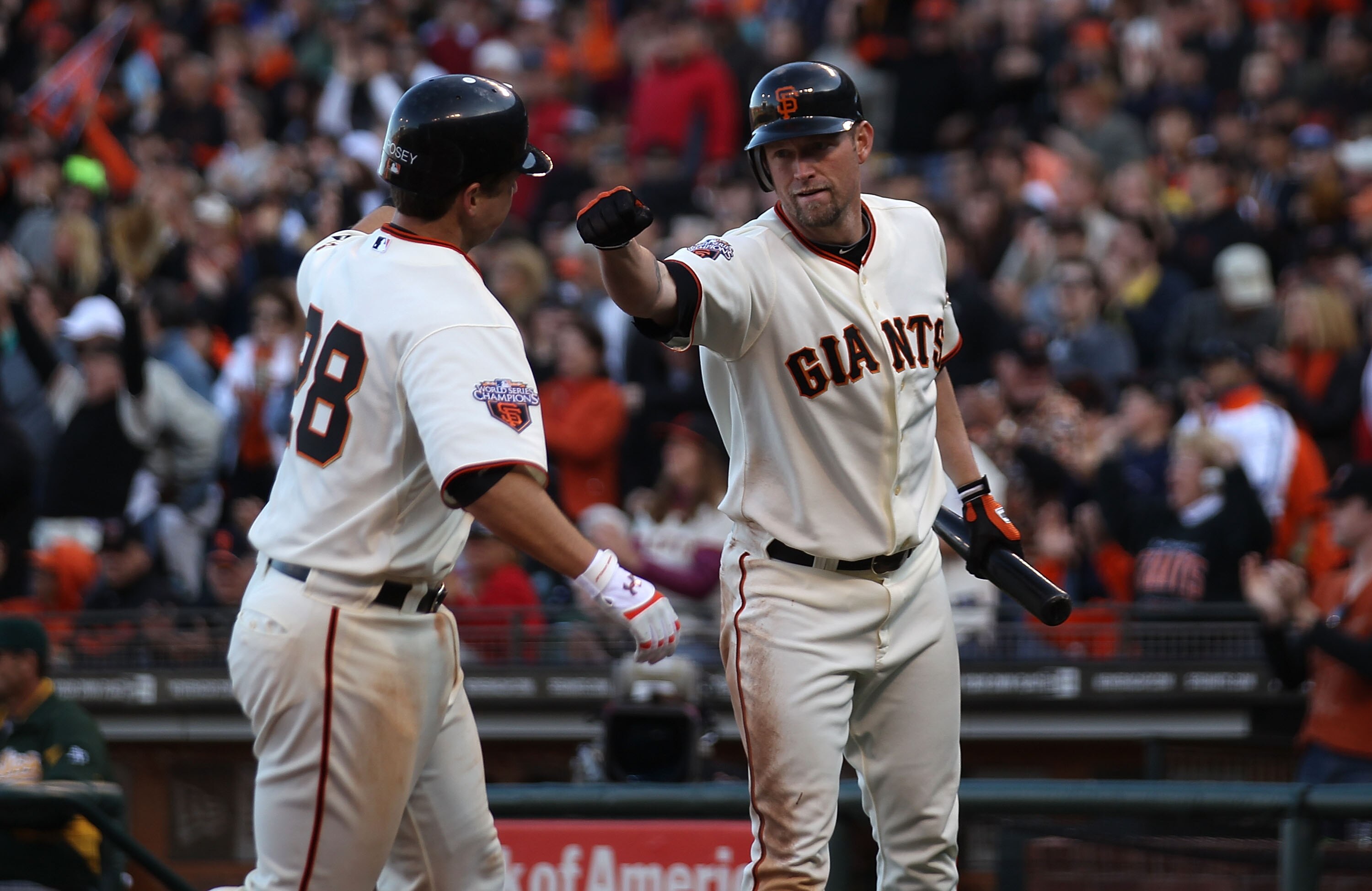 SAN FRANCISCO, CA - MAY 21:  Buster Posey #28 of the San Francisco Giants celebrates with Aubrey Huff #17 after scoring on a single by Cody Ross against the Oakland Athletics during an MLB game at AT&T Park on May 21, 2011 in San Francisco, California.  (