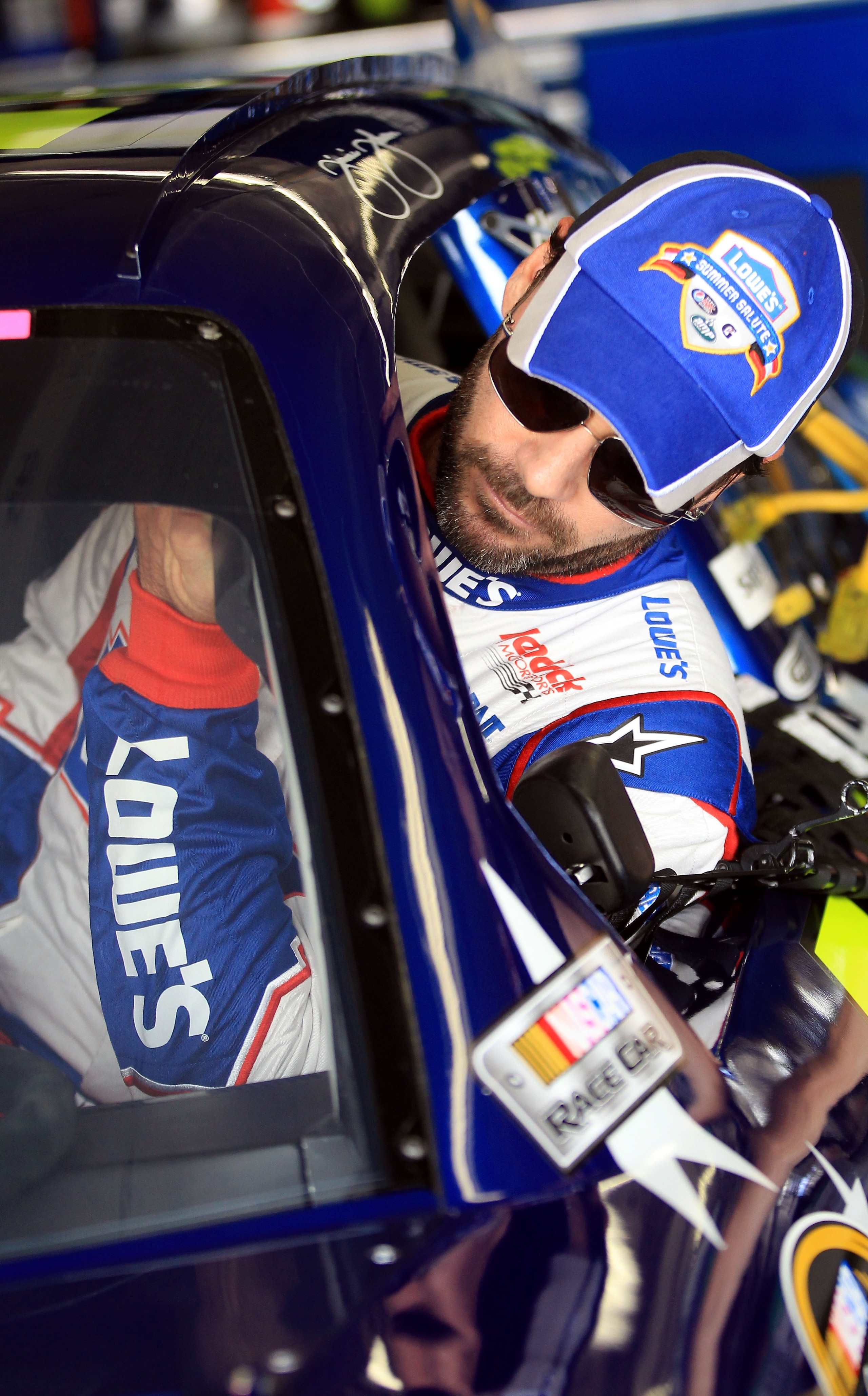 CHARLOTTE, NC - MAY 28:  Jimmie Johnson, driver of the #48 Lowe's Summer Salute Chevrolet, climbs in his car during practice for the NASCAR Sprint Cup Series Coca-Cola 600 at Charlotte Motor Speedway on May 28, 2011 in Charlotte, North Carolina.  (Photo b