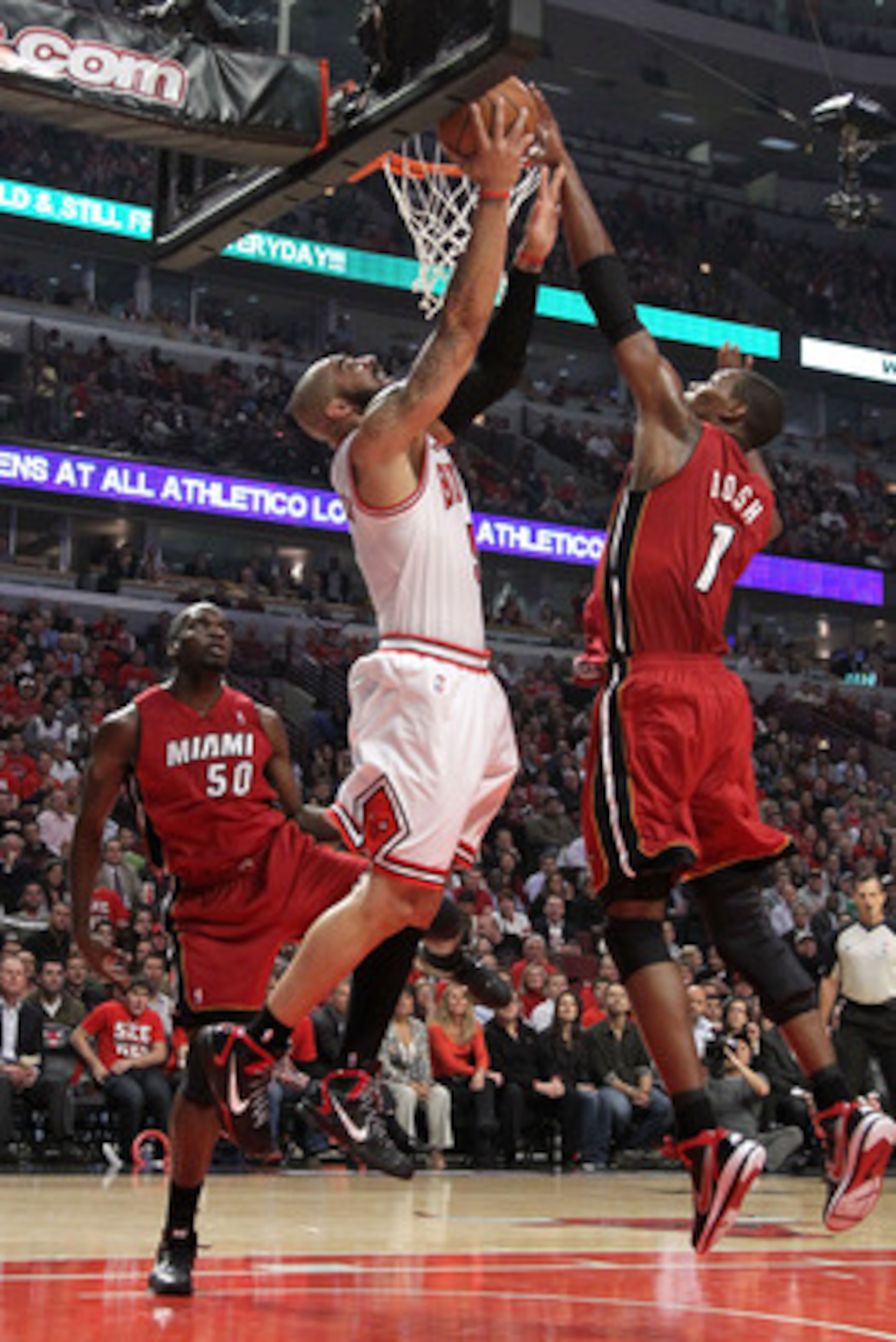 CHICAGO, IL - MAY 26:  Carlos Boozer #5 of the Chicago Bulls attempts a shot against Chris Bosh #1 and Joel Anthony #50 of the Miami Heat in Game Five of the Eastern Conference Finals during the 2011 NBA Playoffs on May 26, 2011 at the United Center in Ch