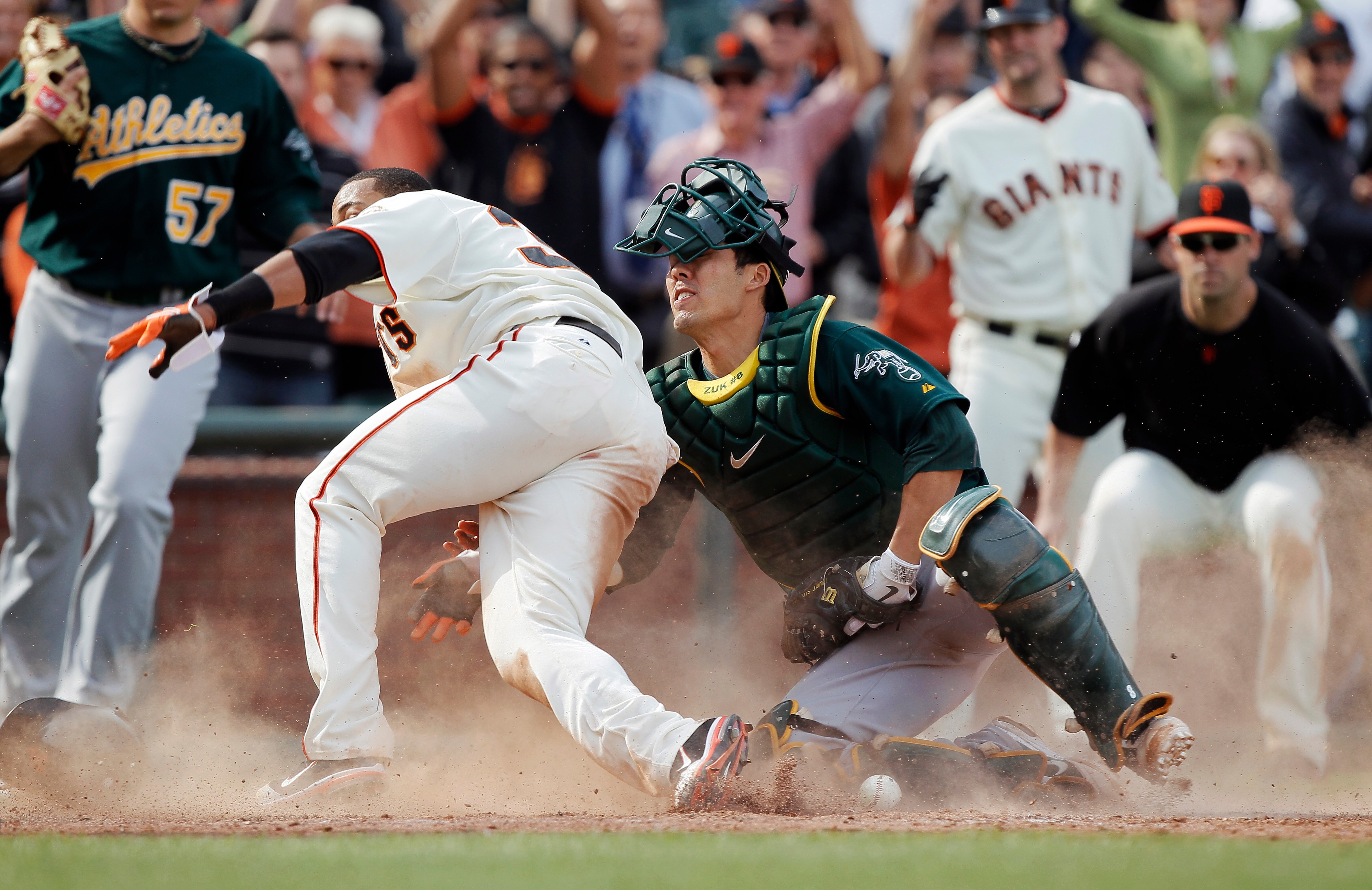 SAN FRANCISCO, CA - MAY 22: Darren Ford #34 of the San Francisco Giants scores the winning run against catcher Kurt Suzuki #8 of the Oakland A's while knocking the ball loose on a single by Emmanuel Burriss in the 11th inning at AT&T Park on May 22, 2011