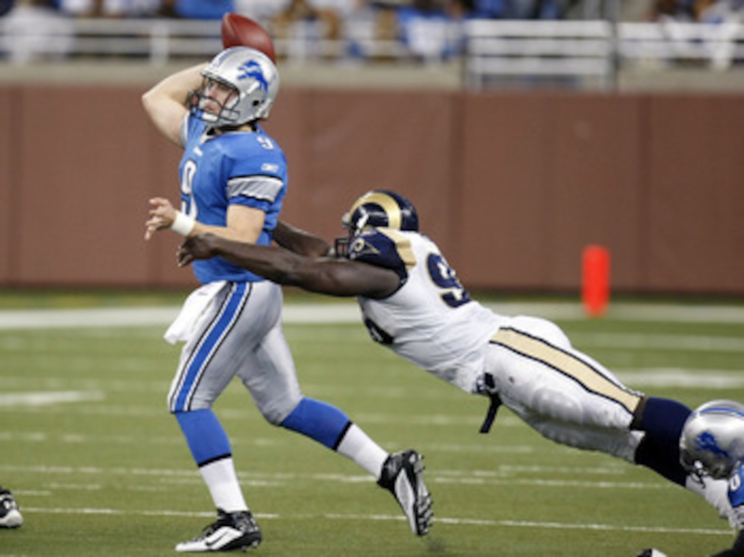 DETROIT , MI - NOVEMBER 01:  Mathew Stafford #9 of the Detroit Lions tries to get a pass of before being tackled by James Hall #96 of the St. Louis Rams on November 1, 2009 at Ford Field in Detroit, Michigan.  (Photo by Gregory Shamus/Getty Images)