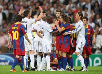 MADRID, SPAIN - APRIL 27:  Lassana Diarra of Real Madrid and Carles Puyol of Barcelona clash during the UEFA Champions League Semi Final first leg match between Real Madrid and Barcelona at Estadio Santiago Bernabeu on April 27, 2011 in Madrid, Spain.  (P