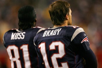 FOXBOROUGH, MA - DECEMBER 23: Randy Moss #81 and Tom Brady #12 of the New England Patriots stand on the sideline against the Miami Dolphins at Gillette Stadium on December 23, 2007 in Foxborough, Massachusetts. Patriots won 28-7. (Photo by Jim Rogash/Gett