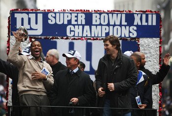 NEW YORK - FEBRUARY 05:  Mayor of New York Michael Bloomberg (C), Michael Strahan (L) and Eli Manning of the New York Giants ride in a float along Broadway, also known as 'The Canyon of Heroes' during Super Bowl XLII victory parade in New York City.  (Pho