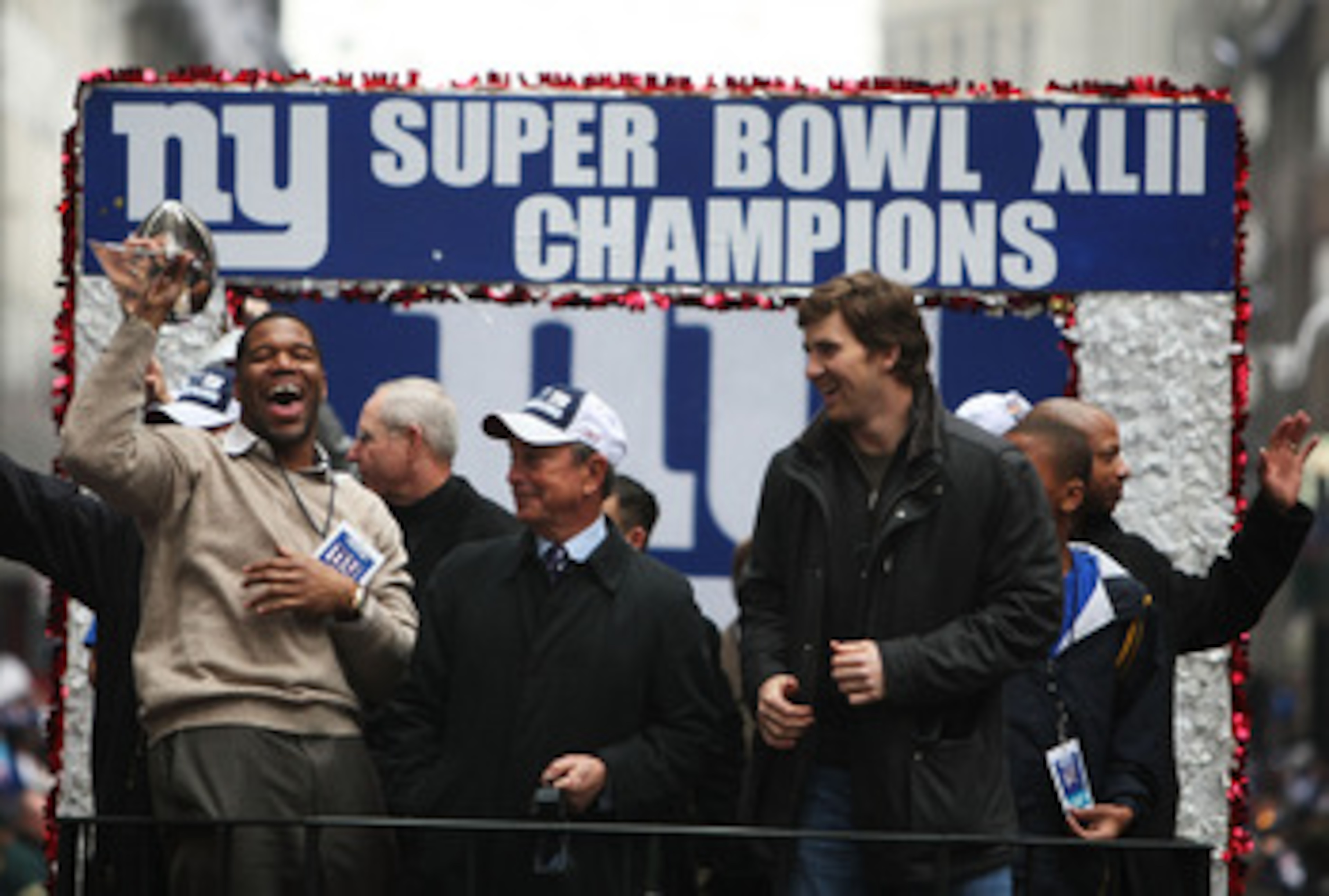 NEW YORK - FEBRUARY 05:  Mayor of New York Michael Bloomberg (C), Michael Strahan (L) and Eli Manning of the New York Giants ride in a float along Broadway, also known as 'The Canyon of Heroes' during Super Bowl XLII victory parade in New York City.  (Pho