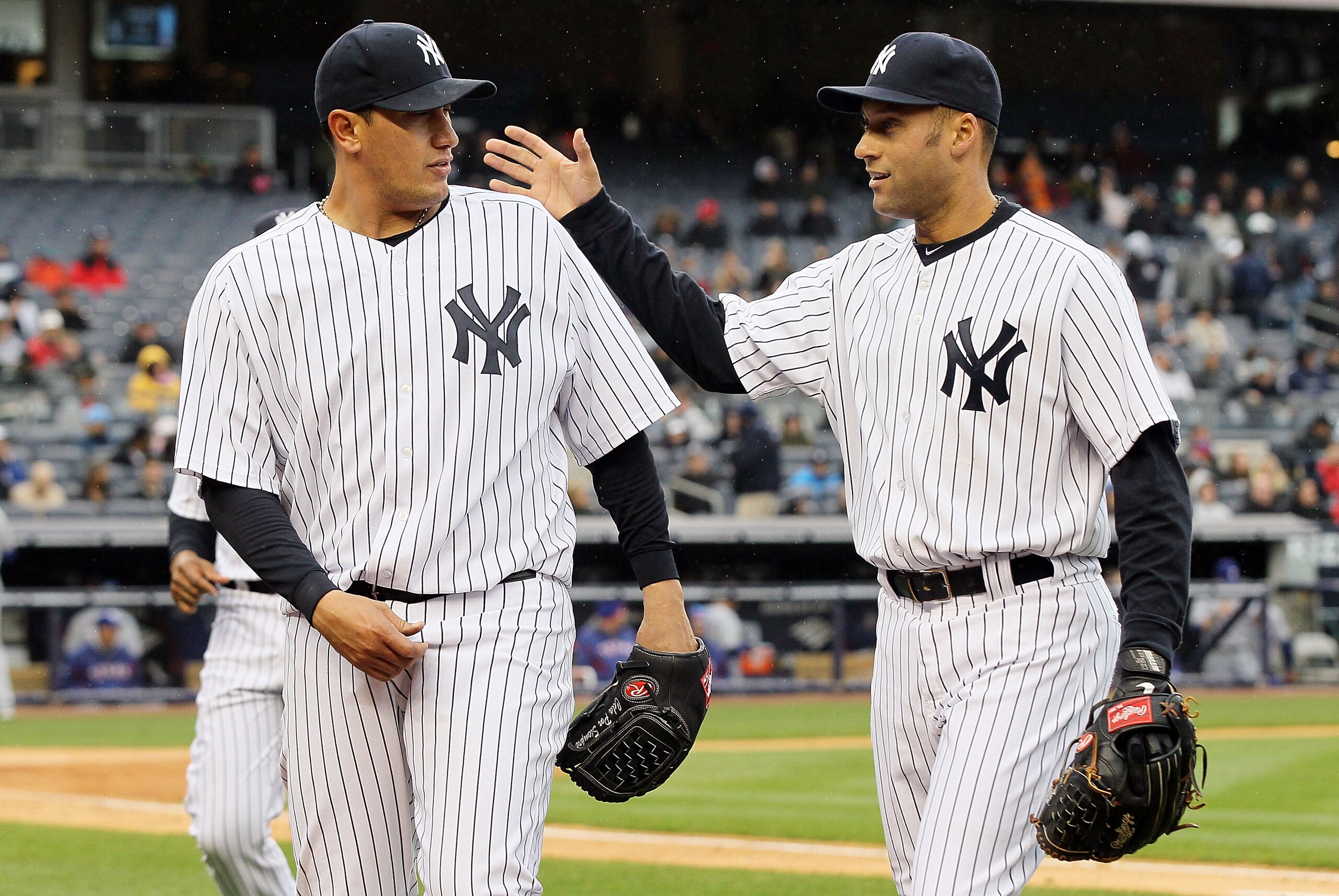 NEW YORK, NY - APRIL 16:  Freddy Garcia #36 and Derek Jeter #2 of the New York Yankees celebrate the final out of an inning against the Texas Rangers on April 16, 2011 at Yankee Stadium in the Bronx borough of New York City.  (Photo by Jim McIsaac/Getty I