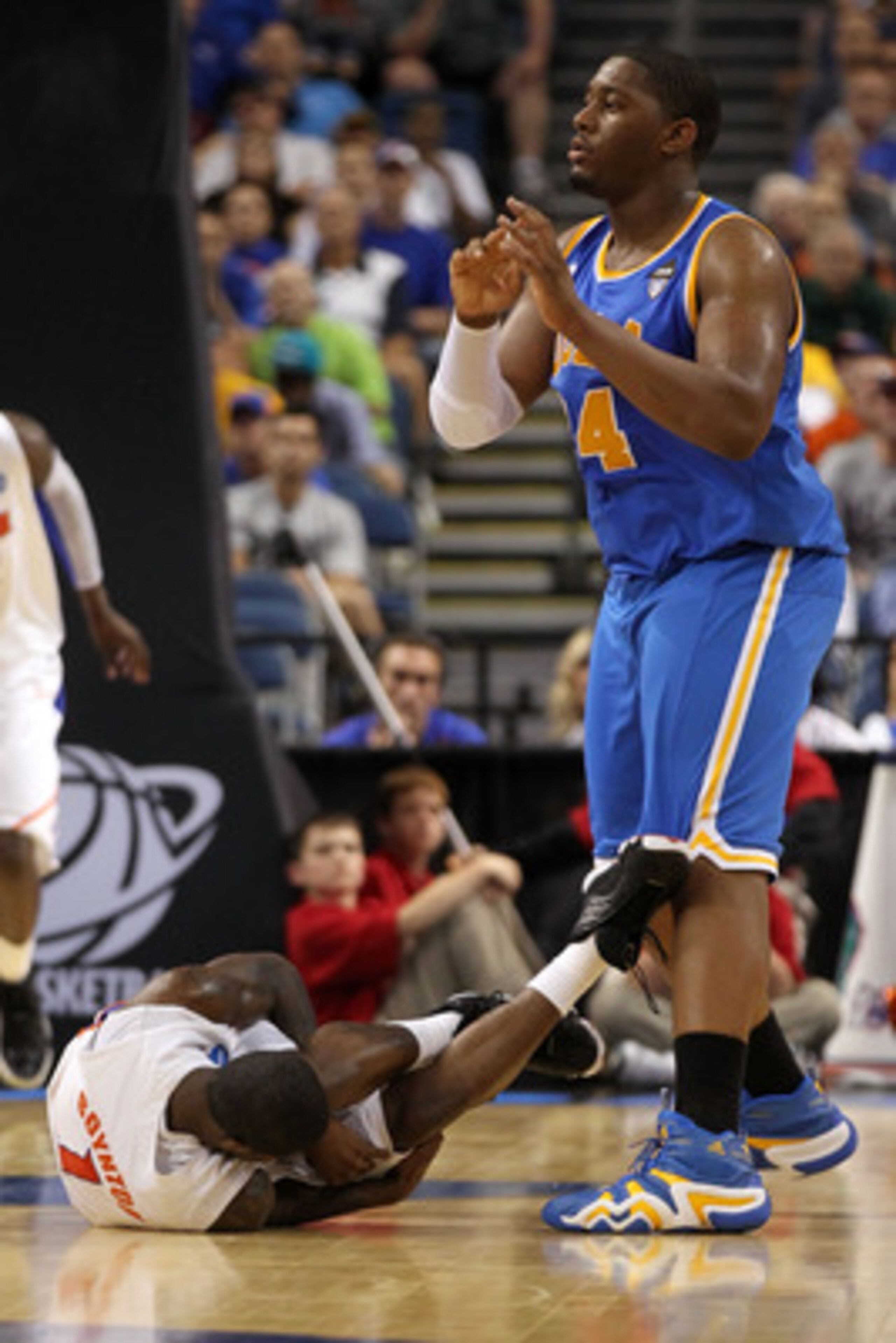 TAMPA, FL - MARCH 19:  Kenny Boynton #1 of the Florida Gators lies on the court in pain after he was injured as Joshua Smith #34 of the UCLA Bruins looks on during the third round of the 2011 NCAA men's basketball tournament at St. Pete Times Forum on Mar