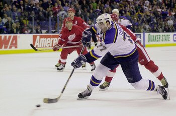 10 Mar 2001: Pierre Turgeon #77 of the St. Louis Blues takes a shot against Chris Osgood #30 of the Detroit Red but hits the post during the overtime period at the Savvis Center in St. Louis, Missouri. The St.Louis Blues and the Detroit Red Wings tied at
