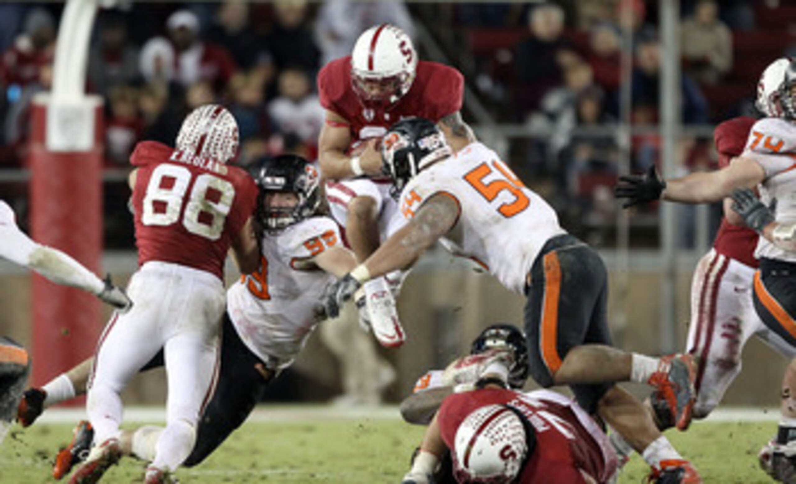 PALO ALTO, CA - NOVEMBER 27:  Tyler Gaffney #25 of the Stanford Cardinal jumps in the air as he is hit by Stephen Paea #54 and Gabe Miller #99 of the Oregon State Beavers at Stanford Stadium on November 27, 2010 in Palo Alto, California.  (Photo by Ezra S