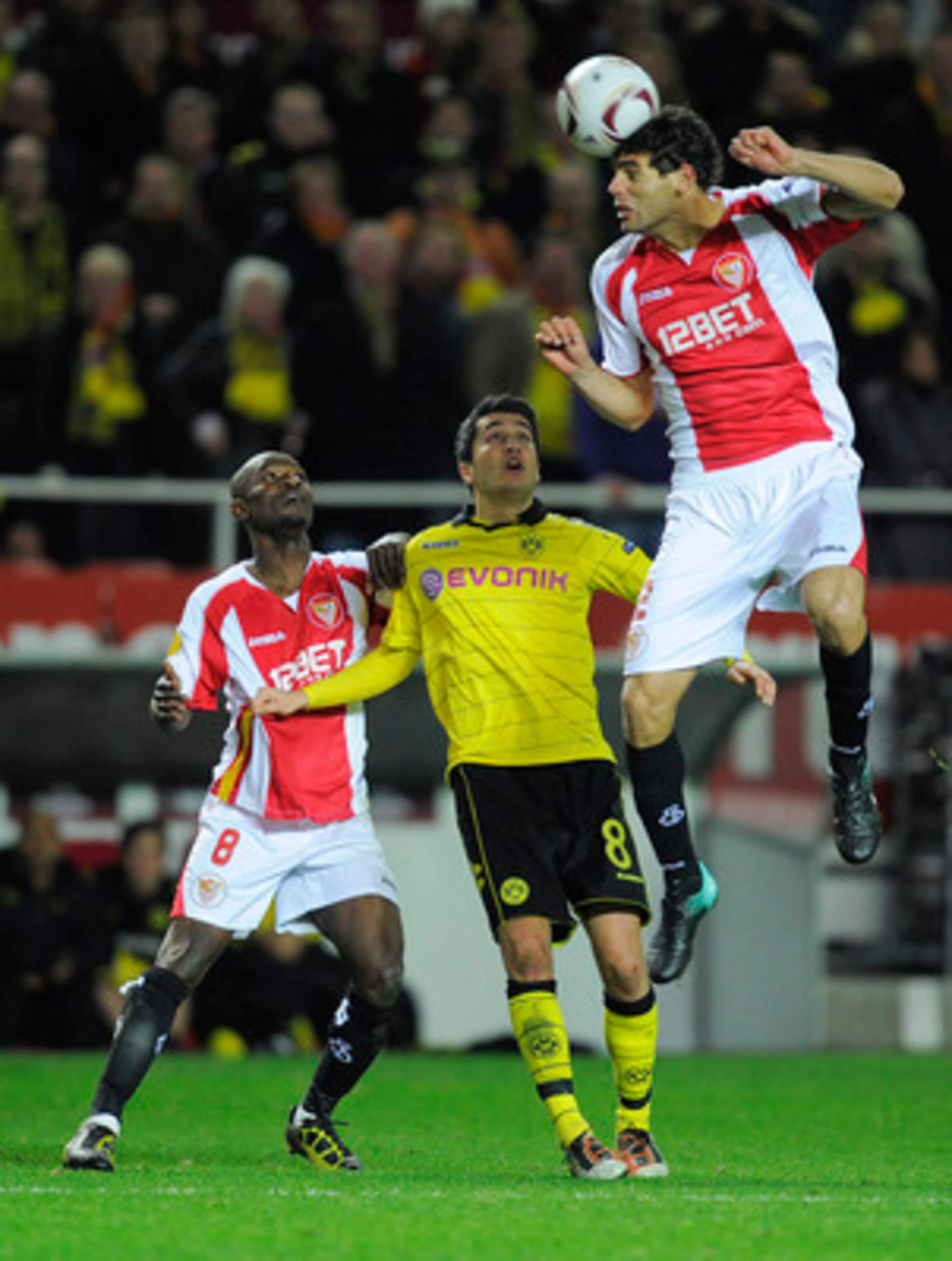 SEVILLE, SPAIN - DECEMBER 15: Nuri Sahin of Borussia Dortmund (C), Didier Zokora of Sevilla FC (L) and Federico Fazio of Sevilla FC duel for a high ball during the UEFA Europa League group J match between Sevilla and Borussia Dortmund at Estadio Ramon San