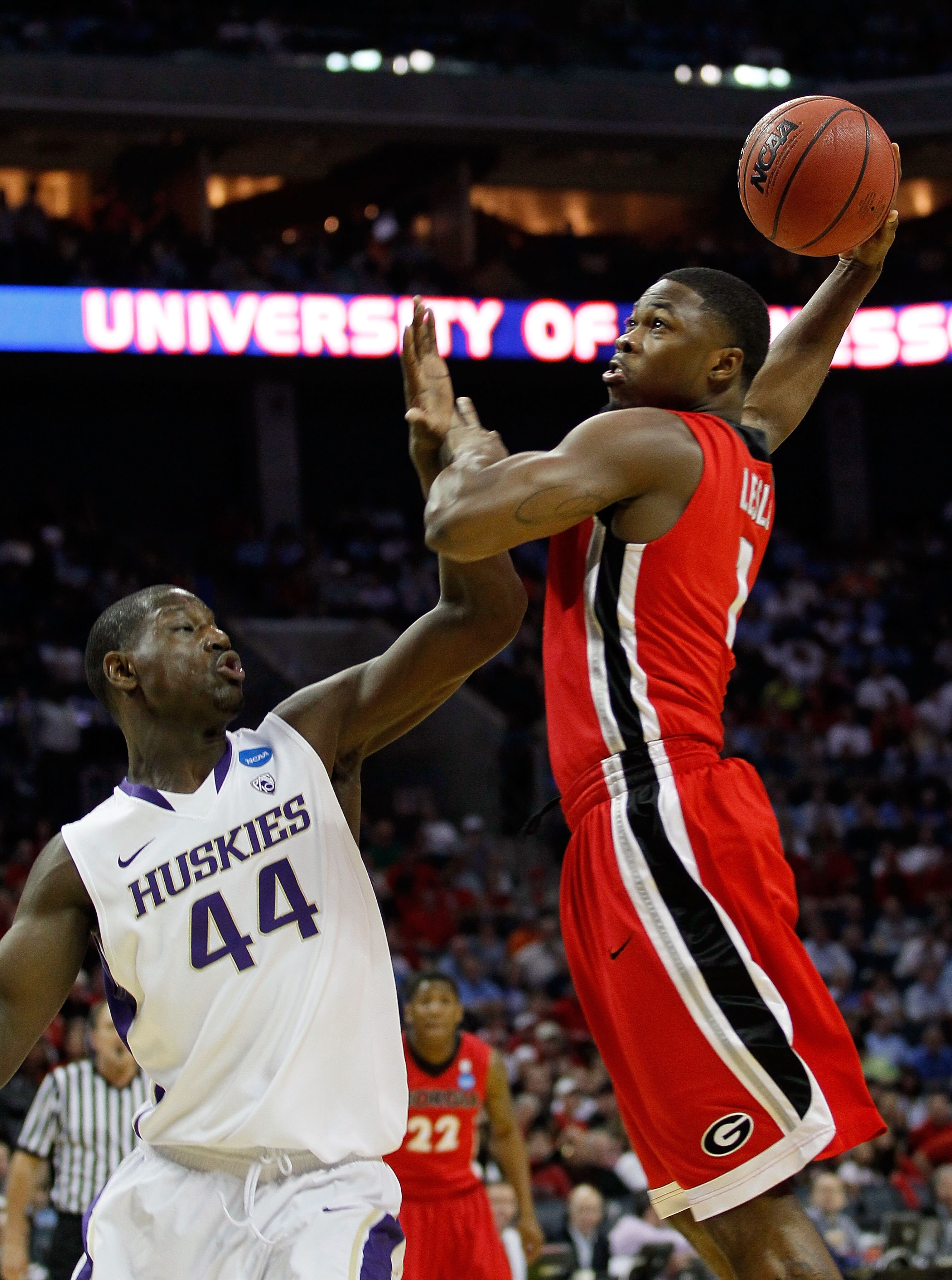 CHARLOTTE, NC - MARCH 18:  Travis Leslie #1 of the Georgia Bulldogs goes up for a dunk and is fouled by Darnell Gant #44 of the Washington Huskies in the first half during the second round of the 2011 NCAA men's basketball tournament at Time Warner Cable