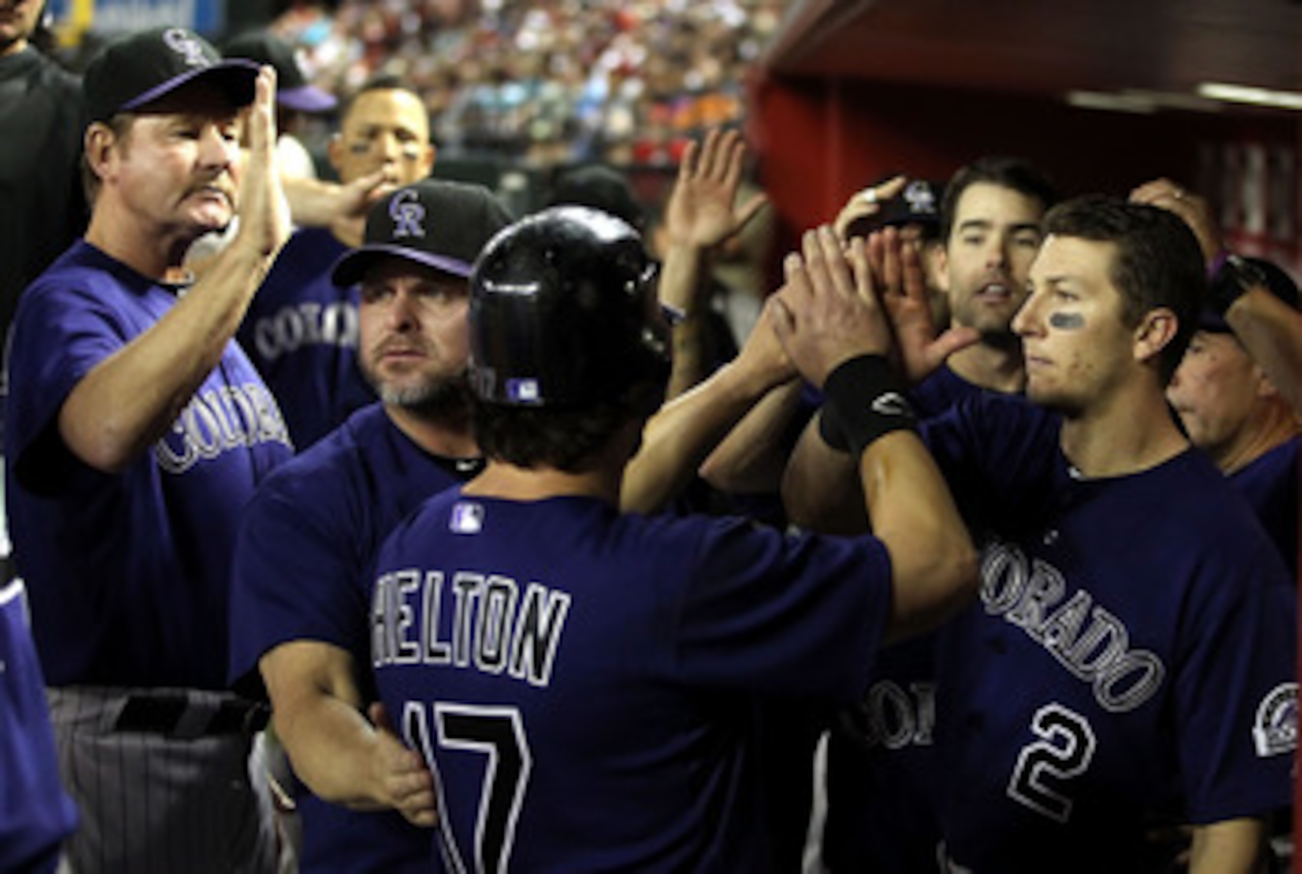 PHOENIX, AZ - MAY 05:  Todd Helton #17 of the Colorado Rockies high fives teammates Carney Lansford, Jason Giambi #23 and Troy Tulowitzki #2 after Helton scored a fourth inning run against the Arizona Diamondbacks during the Major League Baseball game at