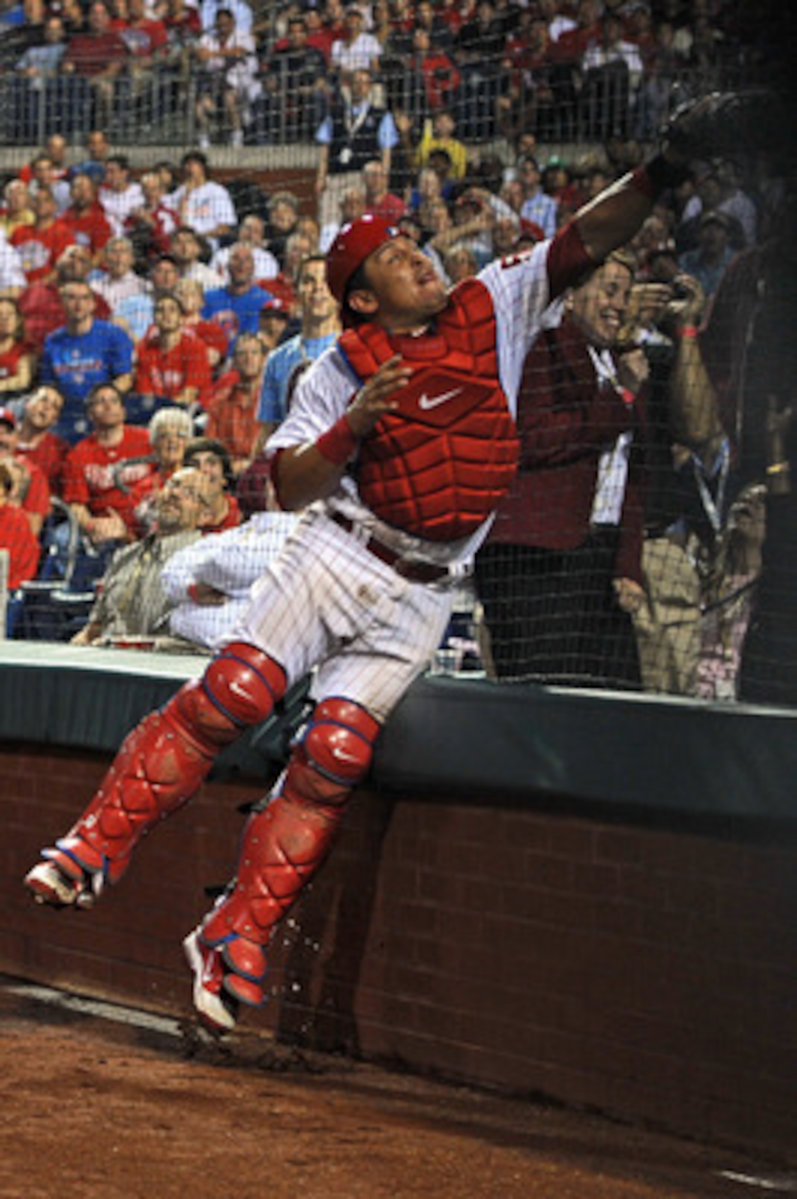 PHILADELPHIA, PA - MAY 23: Carlos Ruiz #51 of the Philadelphia Phillies jumps into the backstop to catch a foul ball during the game against the Cincinnati Reds at Citizens Bank Park on May 23, 2011 in Philadelphia, Pennsylvania. The Phillies won 10-3. (P