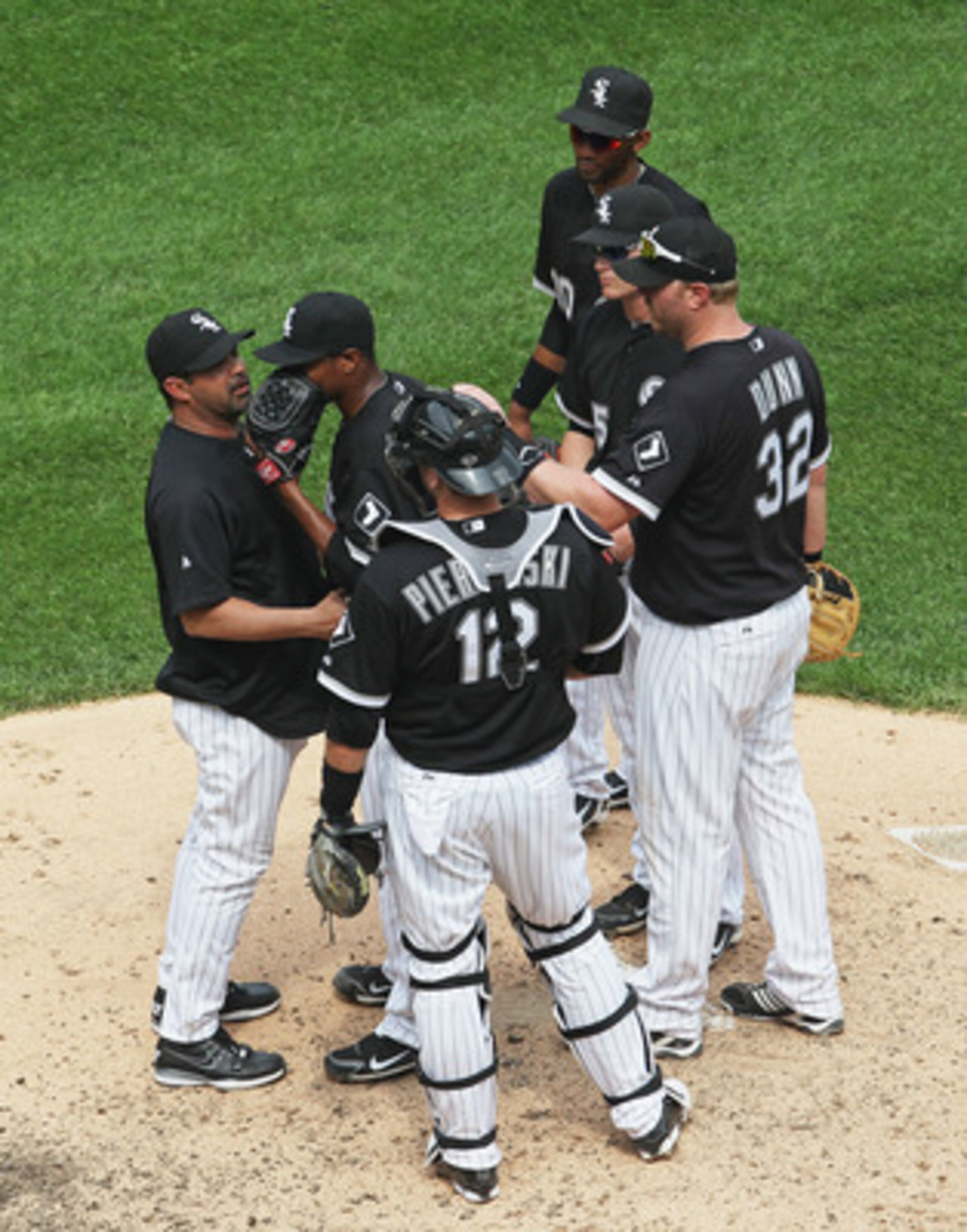 CHICAGO, IL - MAY 22:  Manager Ozzie Guillen #13 of the Chicago White Sox (L) talks with pitcher Edwin Jackson #33 as (L-R) A.J. Pierzynski #12, Adam Dunn #32, Gordon Beckham #15 and Alexei Ramirez #10 listen during a game against the Los Angeles Dodgers 