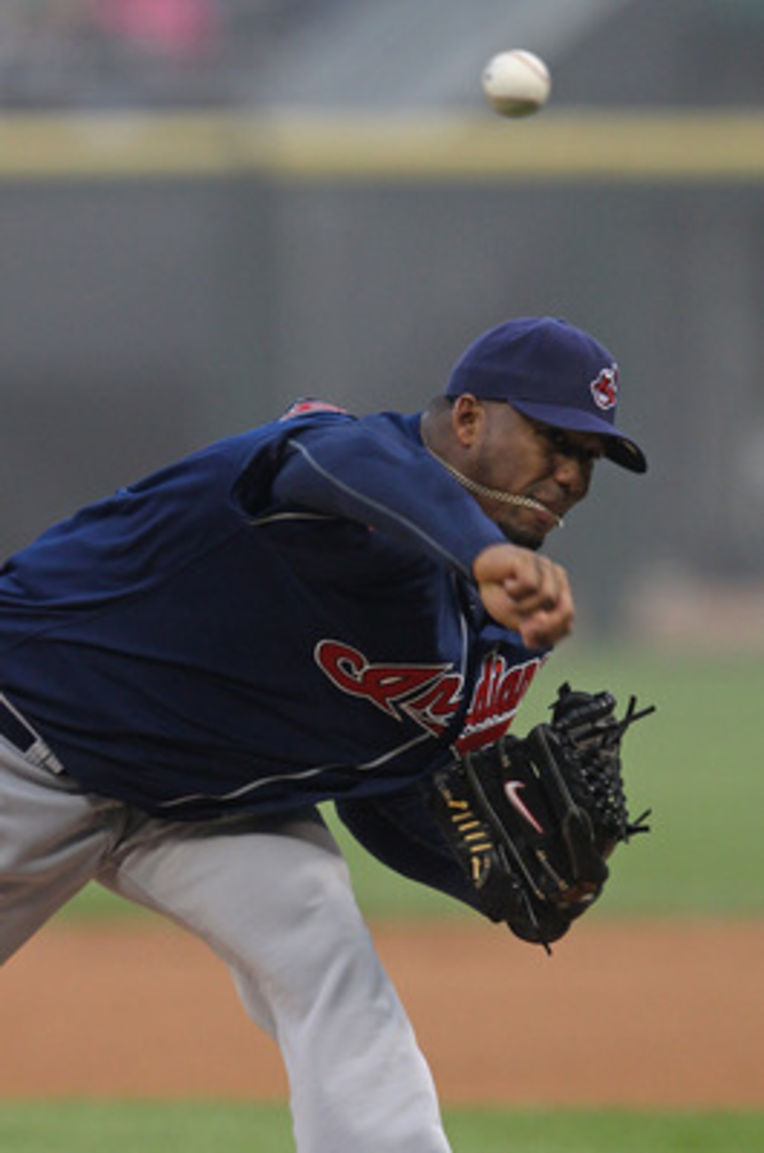 CHICAGO, IL - MAY 19: Starting pitcher Fausto Carmona #55 of the Cleveland Indians gets his neck chain caught in his mouth as the throws against the Chicago White Sox at U.S. Cellular Field on May 19, 2011 in Chicago, Illinois. (Photo by Jonathan Daniel/G