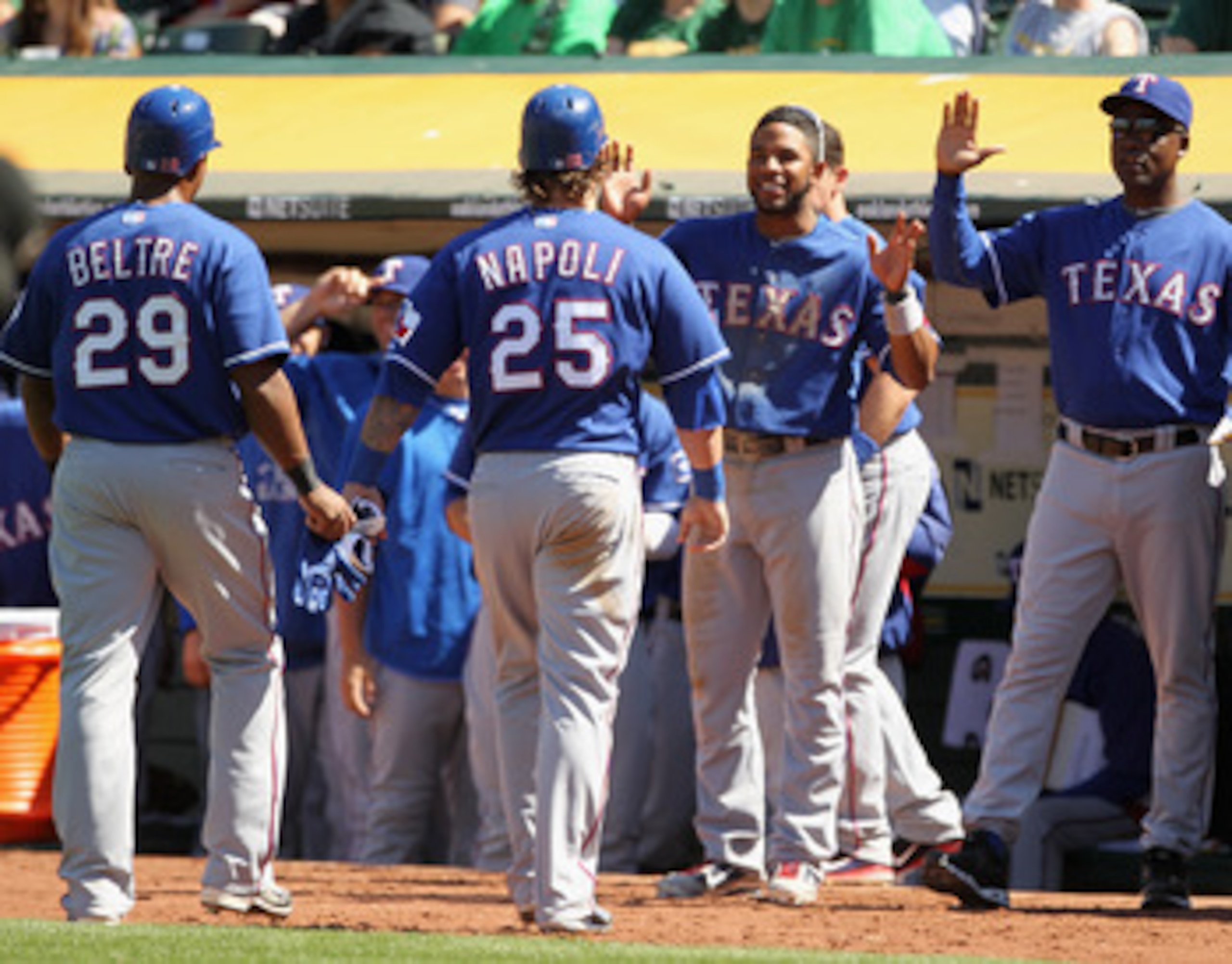 OAKLAND, CA - APRIL 30:  Adrian Beltre #29 and Mike Napoli #25 of the Texas Rangers are congratulated by teammates after they scored on a double by Yorvit Torrealba #8 of the Texas Rangers in the eighth inning of their game against the Oakland Athletics a