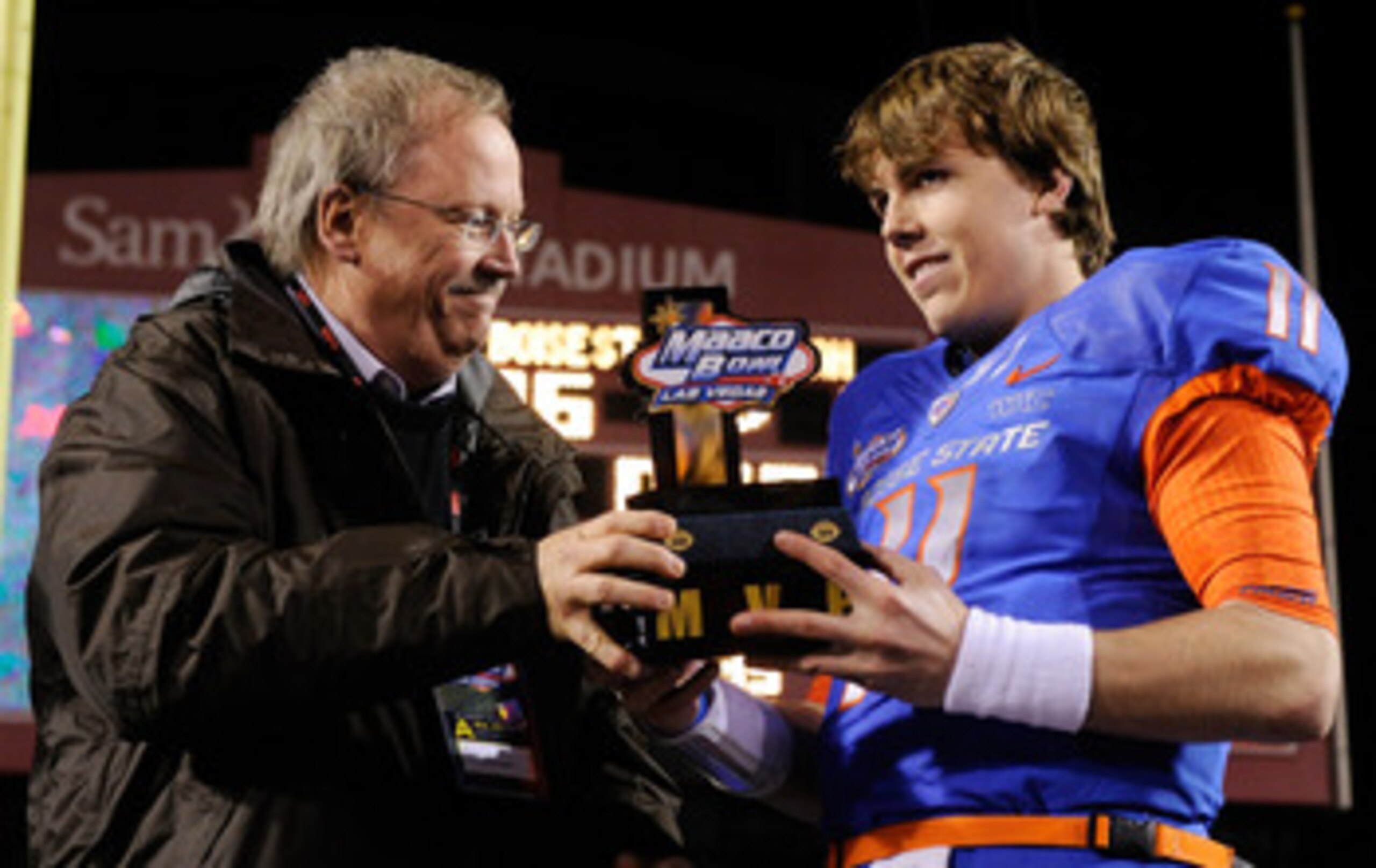 LAS VEGAS, NV - DECEMBER 22:  MAACO President Dave Lapps (L) gives the most valuable player trophy to quarterback Kellen Moore #11 of the Boise State Broncos after the team's 26-3 victory over the Utah Utes in the MAACO Bowl Las Vegas at Sam Boyd Stadium 