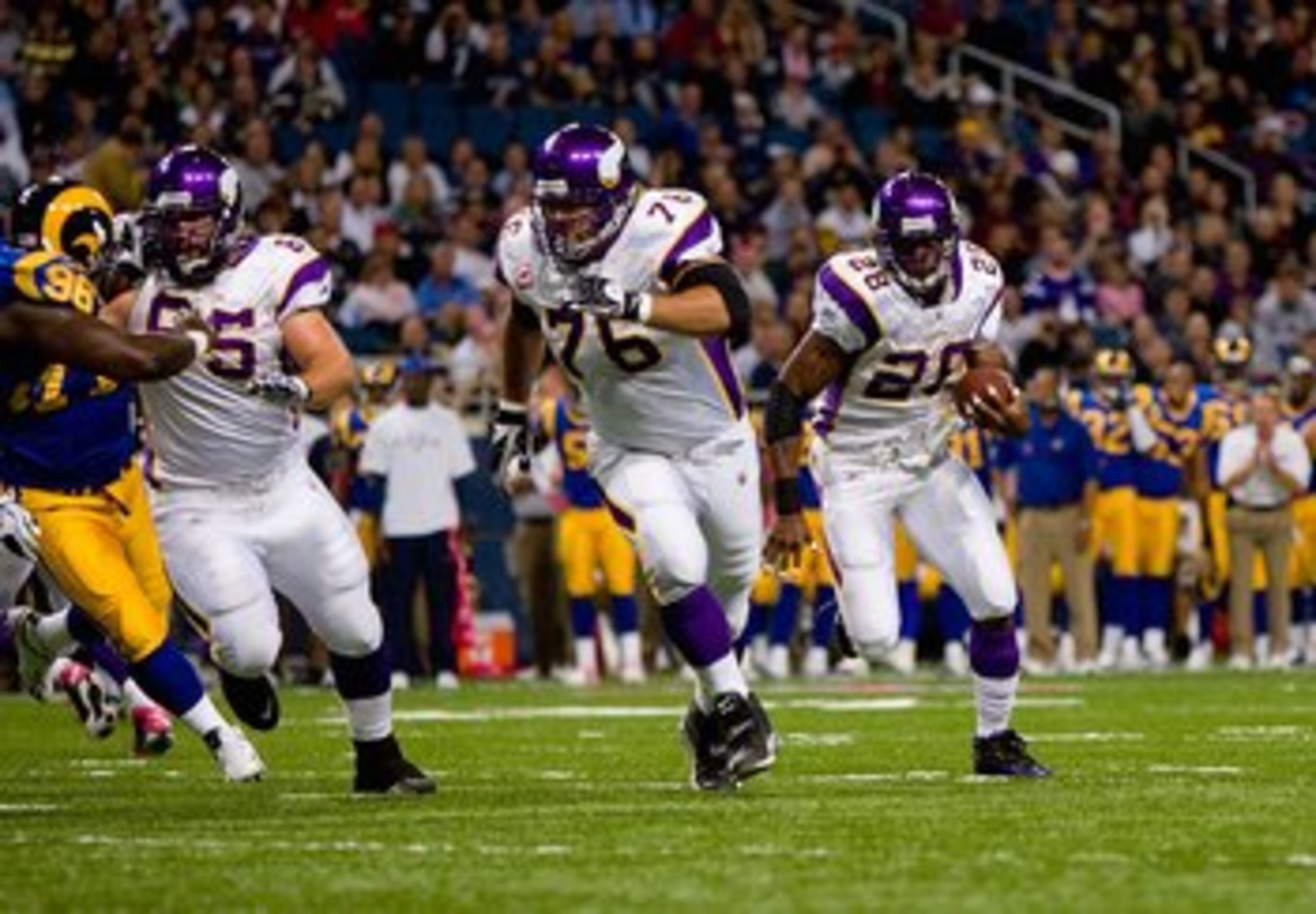 ST. LOUIS - OCTOBER 11:  Adrian Peterson #28 of the Minnesota Vikings runs to his left toward the end zone in front of teammates Steve Hutchinson #76 and John Sullivan #65 during their NFL game against the St. Louis Rams at the Edward Jones Dome on Octobe
