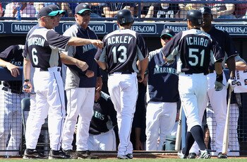 PEORIA, AZ - MARCH 04:  Dustin Ackley #13 of the Seattle Mariners is congratulated by teammates after scoring a run on a sacrifice fly hit by Ichiro Suzuki #51 during the third inning of the spring training game against the Cincinnati Reds at Peoria Stadi