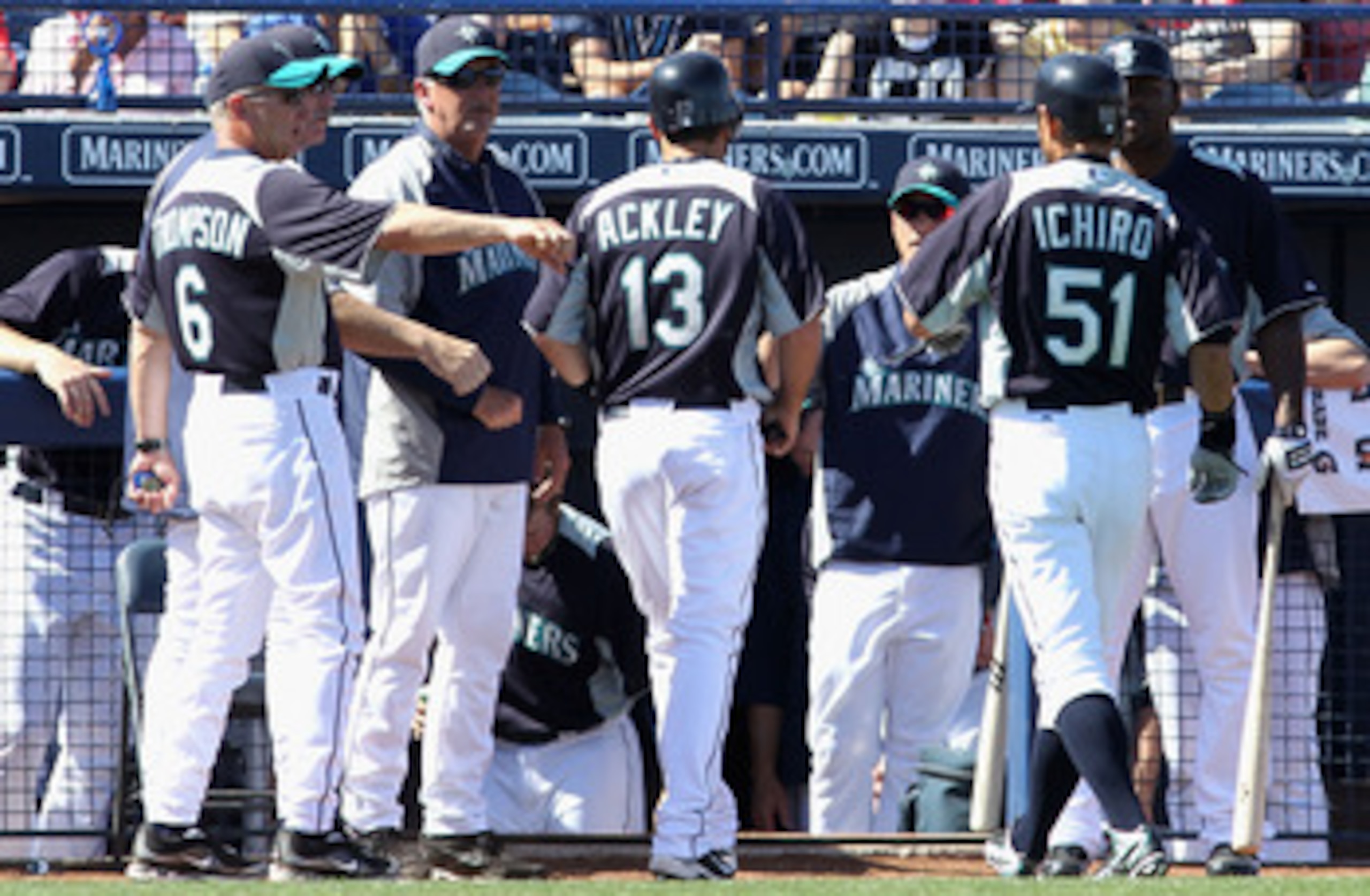 PEORIA, AZ - MARCH 04:  Dustin Ackley #13 of the Seattle Mariners is congratulated by teammates after scoring a run on a sacrifice fly hit by Ichiro Suzuki #51 during the third inning of the spring training game against the Cincinnati Reds at Peoria Stadi