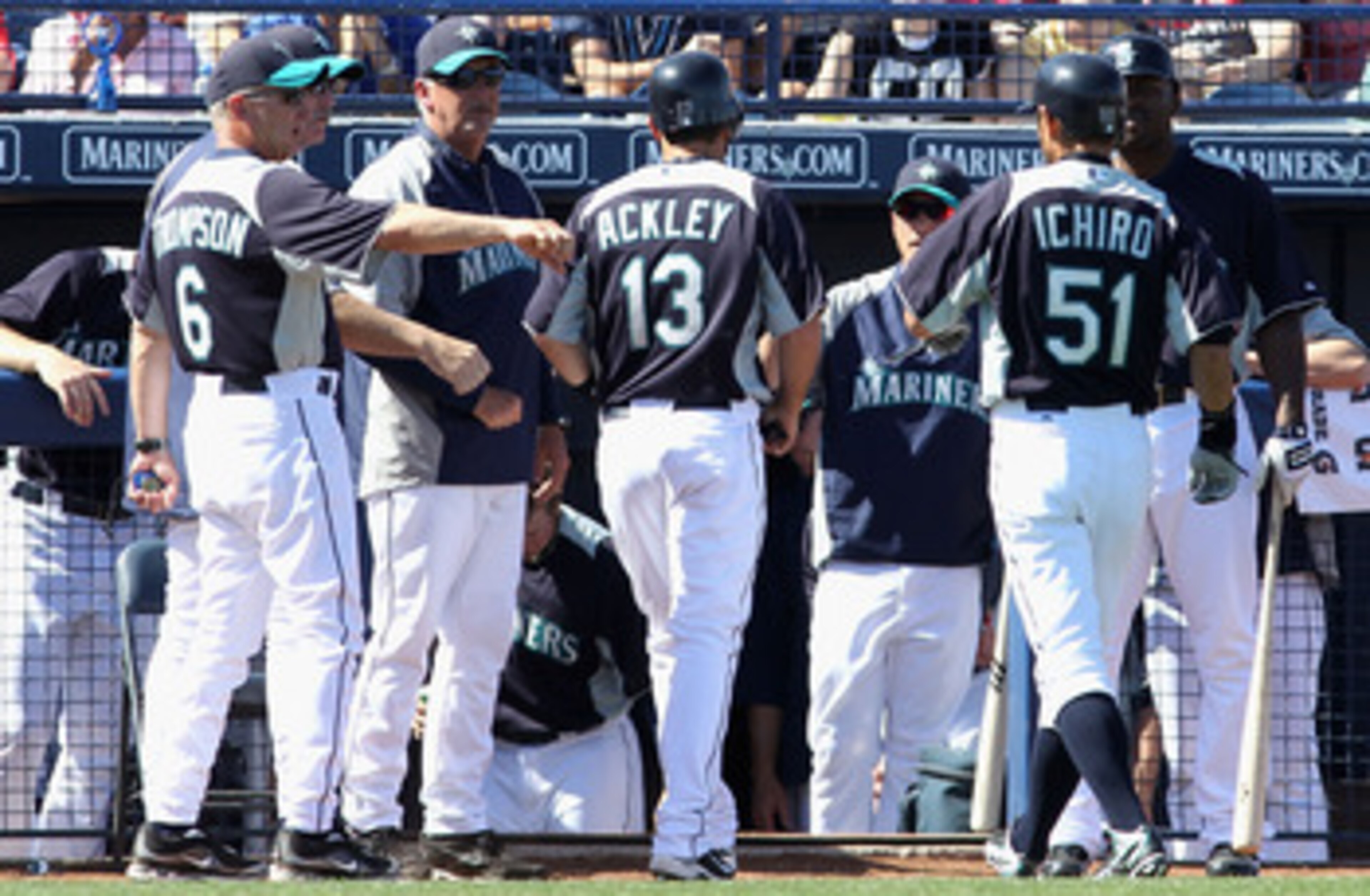 PEORIA, AZ - MARCH 04:  Dustin Ackley #13 of the Seattle Mariners is congratulated by teammates after scoring a run on a sacrifice fly hit by Ichiro Suzuki #51 during the third inning of the spring training game against the Cincinnati Reds at Peoria Stadi
