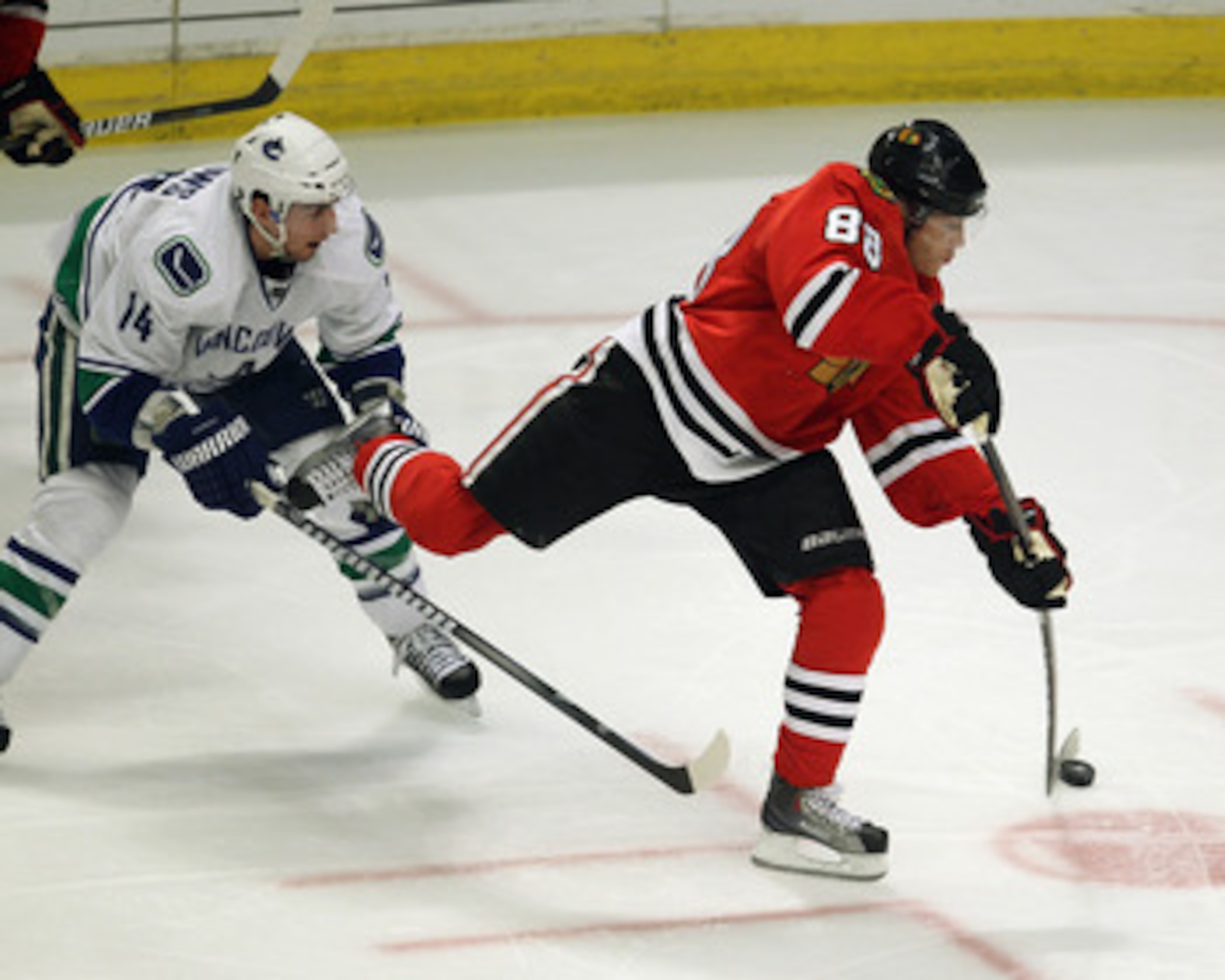 CHICAGO, IL - APRIL 24: Patrick Kane #88 of the Chicago Blackhawks shoots the puck in front of Alexandre Burrows #14 of the Vancouver Canucks in Game Six of the Western Conference Quarterfinals during the 2011 NHL Stanley Cup Playoffs at the United Center CHICAGO, IL - APRIL 24: Patrick Kane #88 of the Chicago Blackhawks shoots the puck in front of Alexandre Burrows #14 of the Vancouver Canucks in Game Six of the Western Conference Quarterfinals during the 2011 NHL Stanley Cup Playoffs at the United Center