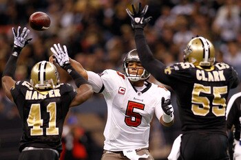 NEW ORLEANS, LA - JANUARY 02:  Quarterback Josh Freeman #5 of the Tampa Bay Buccaneers throws a pass over Roman Harper #41 and Danny Clark #55  of the New Orleans Saints at the Louisiana Superdome on January 2, 2011 in New Orleans, Louisiana.   The Buccan