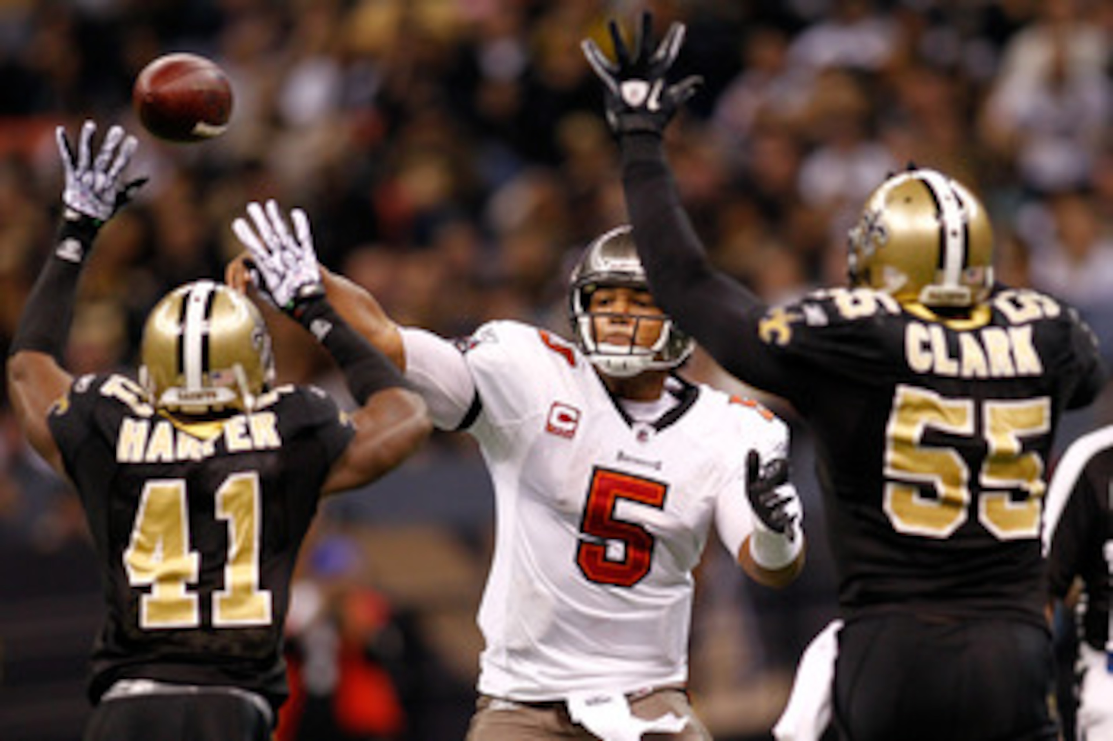 NEW ORLEANS, LA - JANUARY 02:  Quarterback Josh Freeman #5 of the Tampa Bay Buccaneers throws a pass over Roman Harper #41 and Danny Clark #55  of the New Orleans Saints at the Louisiana Superdome on January 2, 2011 in New Orleans, Louisiana.   The Buccan