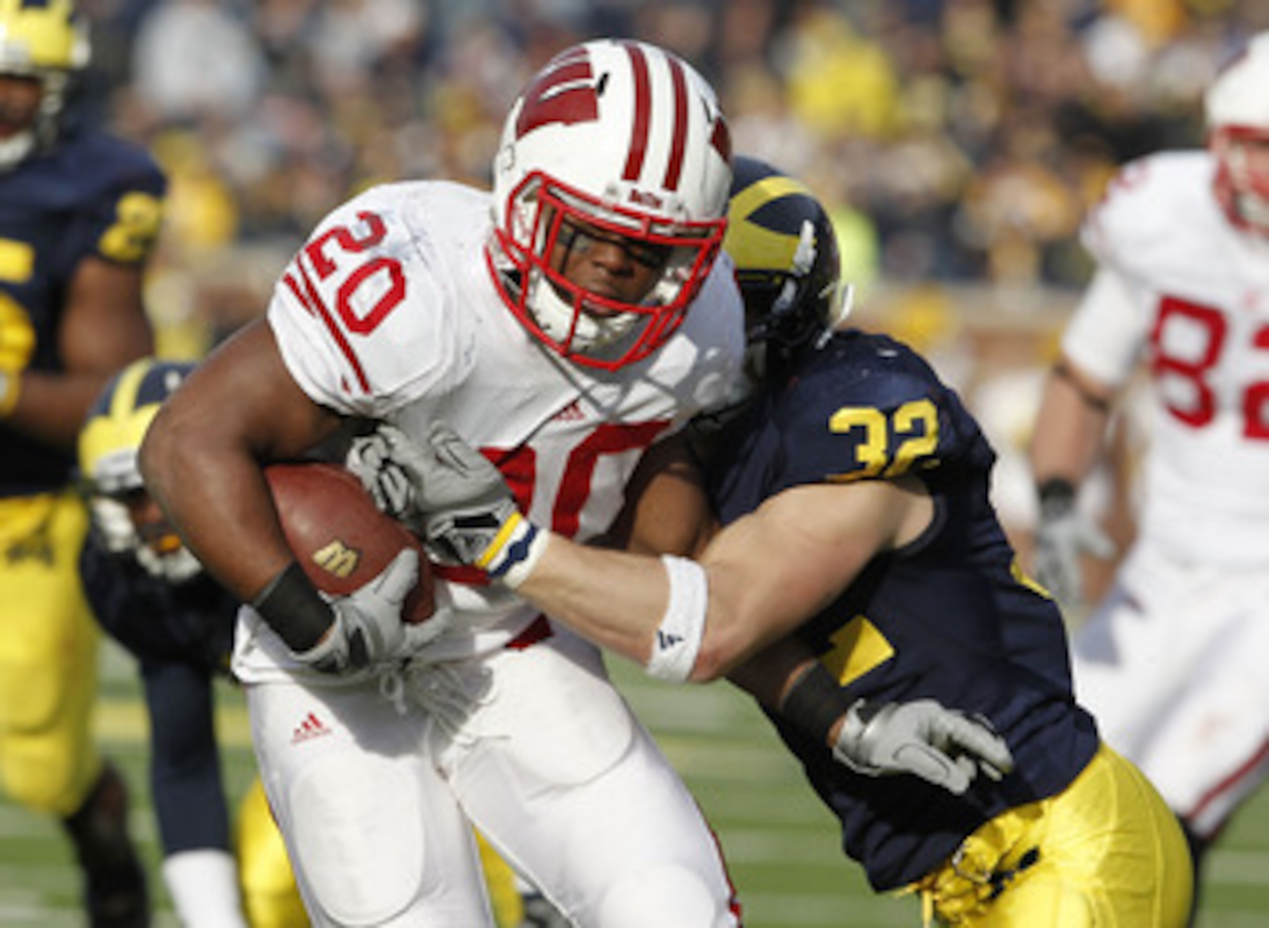 ANN ARBOR, MI - NOVEMBER 20: James White #20 of the Wisconsin Badgers treies to get around the tackle of Jordan Kovacs #32 of the Michigan Wolverines at Michigan Stadium on November 20, 2010 in Ann Arbor, Michigan. Wisconson won the game 48-28. (Photo b ANN ARBOR, MI - NOVEMBER 20: James White #20 of the Wisconsin Badgers treies to get around the tackle of Jordan Kovacs #32 of the Michigan Wolverines at Michigan Stadium on November 20, 2010 in Ann Arbor, Michigan. Wisconson won the game 48-28. (Photo b