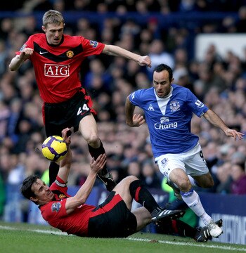 LIVERPOOL, ENGLAND - FEBRUARY 20:  Landon Donovan of Everton is challenged by Darren Fletcher and Gary Neville of Manchester United at Goodison Park on February 20, 2010 in Liverpool, England.  (Photo by Ross Kinnaird/Getty Images)