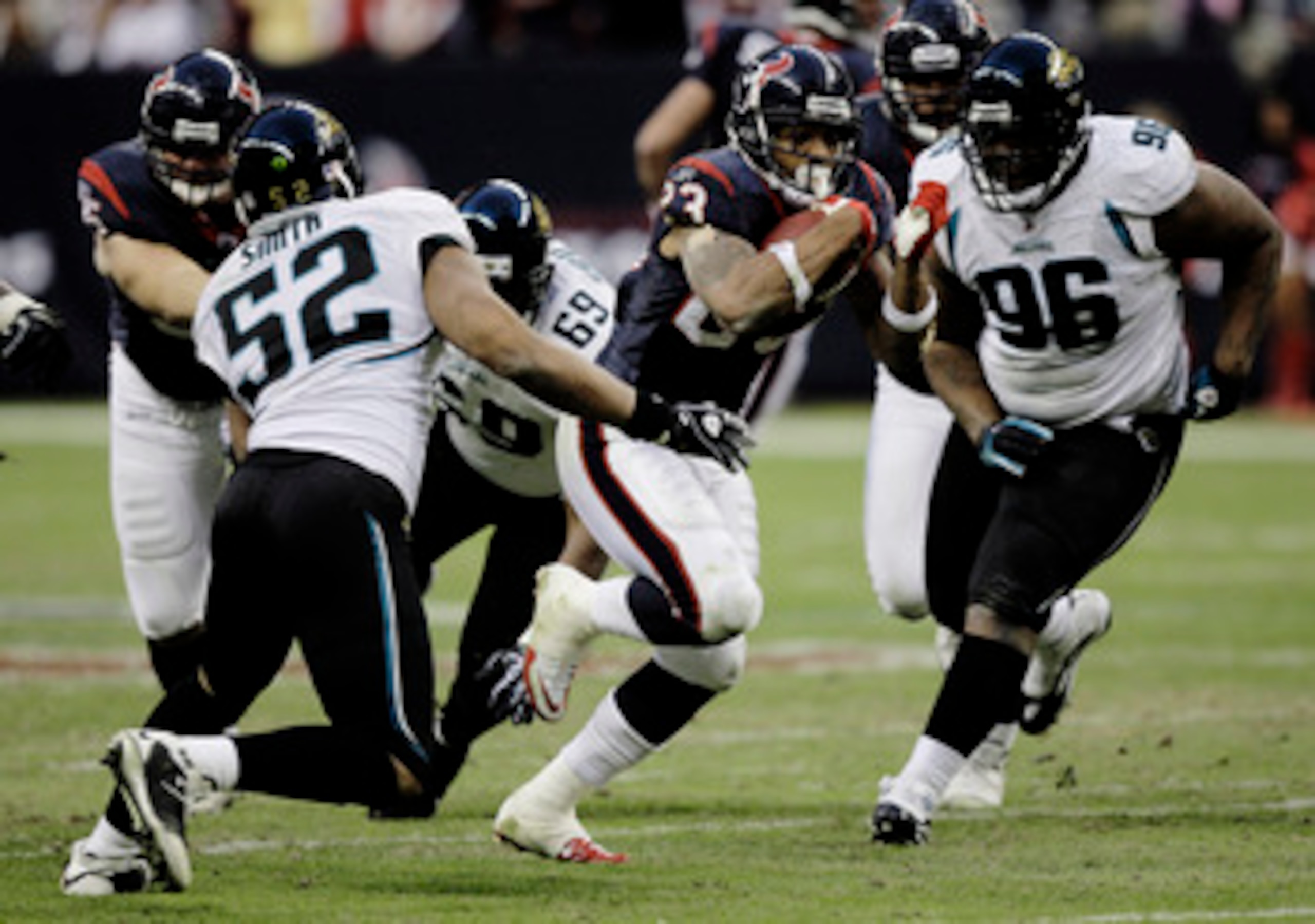 HOUSTON - JANUARY 02:  Running back Arian Foster #23 of the Houston Texans rushes past linebacker Daryl Smith #52 of the Jacksonville Jaguars and  Terrance Knighton #96 at Reliant Stadium on January 2, 2011 in Houston, Texas.  (Photo by Bob Levey/Getty Im
