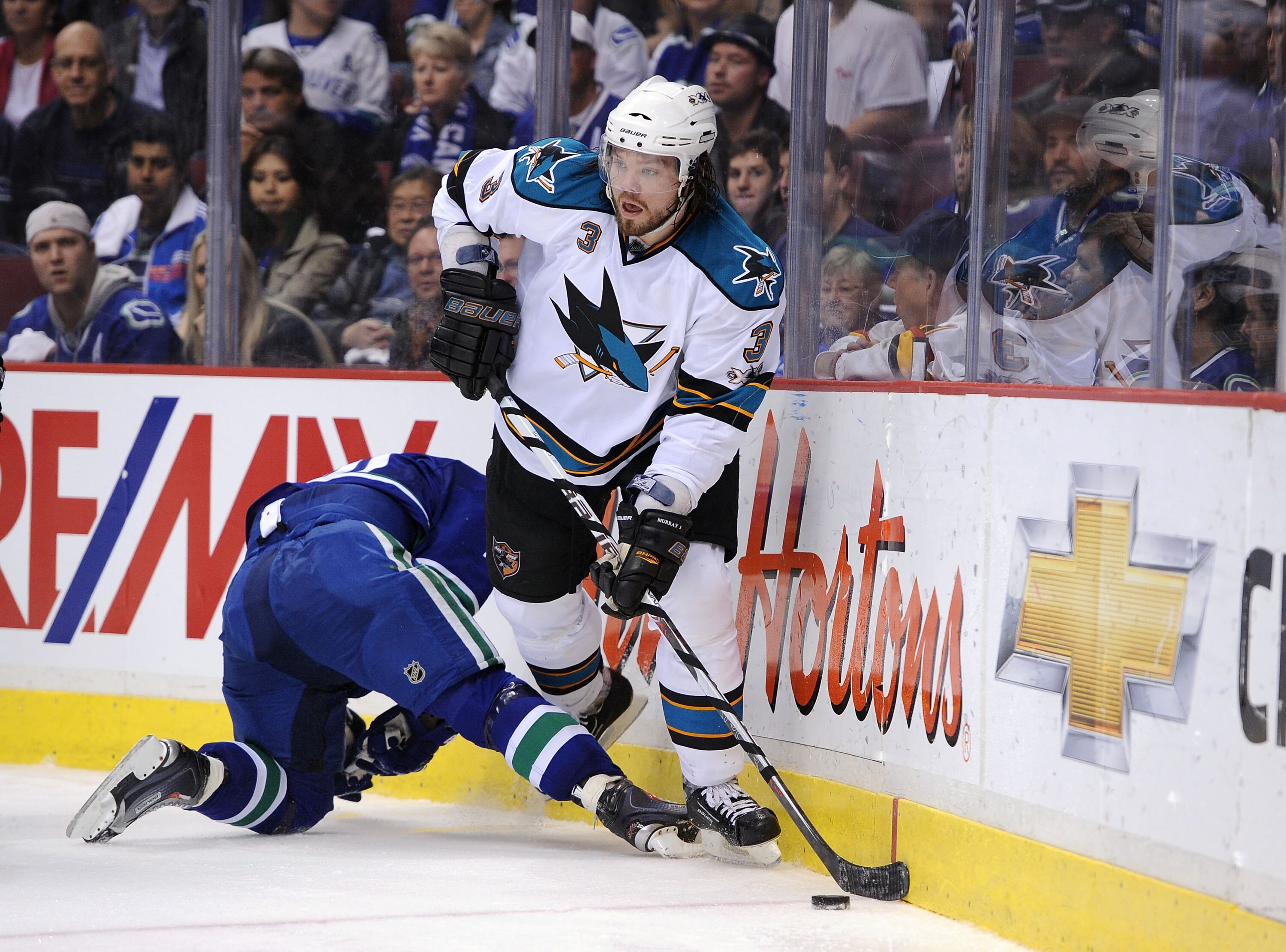 VANCOUVER, CANADA - MAY 18:  Douglas Murray #3 of the San Jose Sharks plays the puck along the end boards  in Game Two of the Western Conference Finals against the Vancouver Canucks during the 2011 Stanley Cup Playoffs at Rogers Arena on May 18, 2011 in V