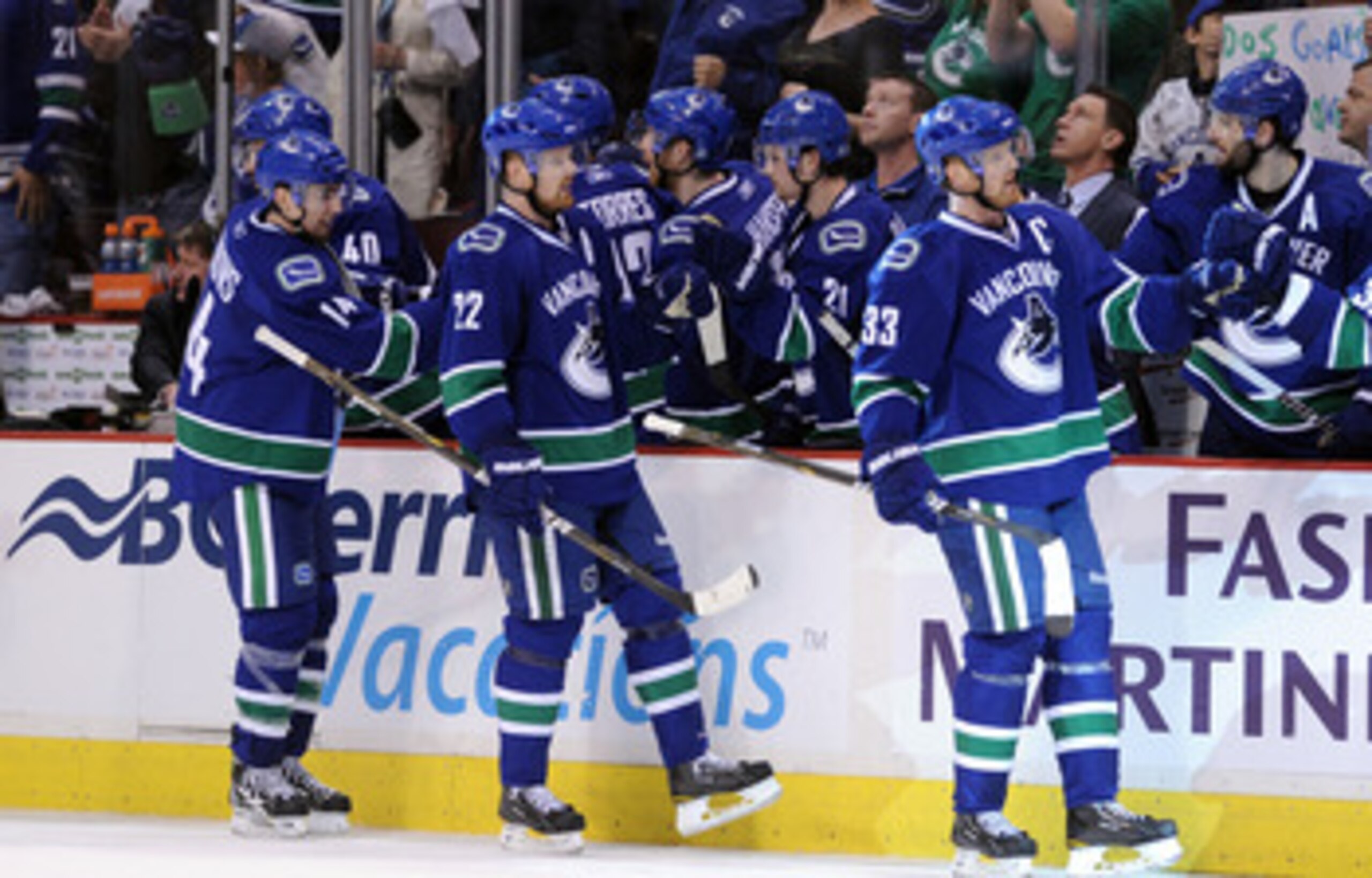 VANCOUVER, CANADA - MAY 15:  Alex Burrows #14, Daniel Sedin #22 and Henrik Sedin #33 of the Vancouver Canucks skate by the Canucks bench to celebrate a goal in the third period against the San Jose Sharks in Game One of the Western Conference Finals durin