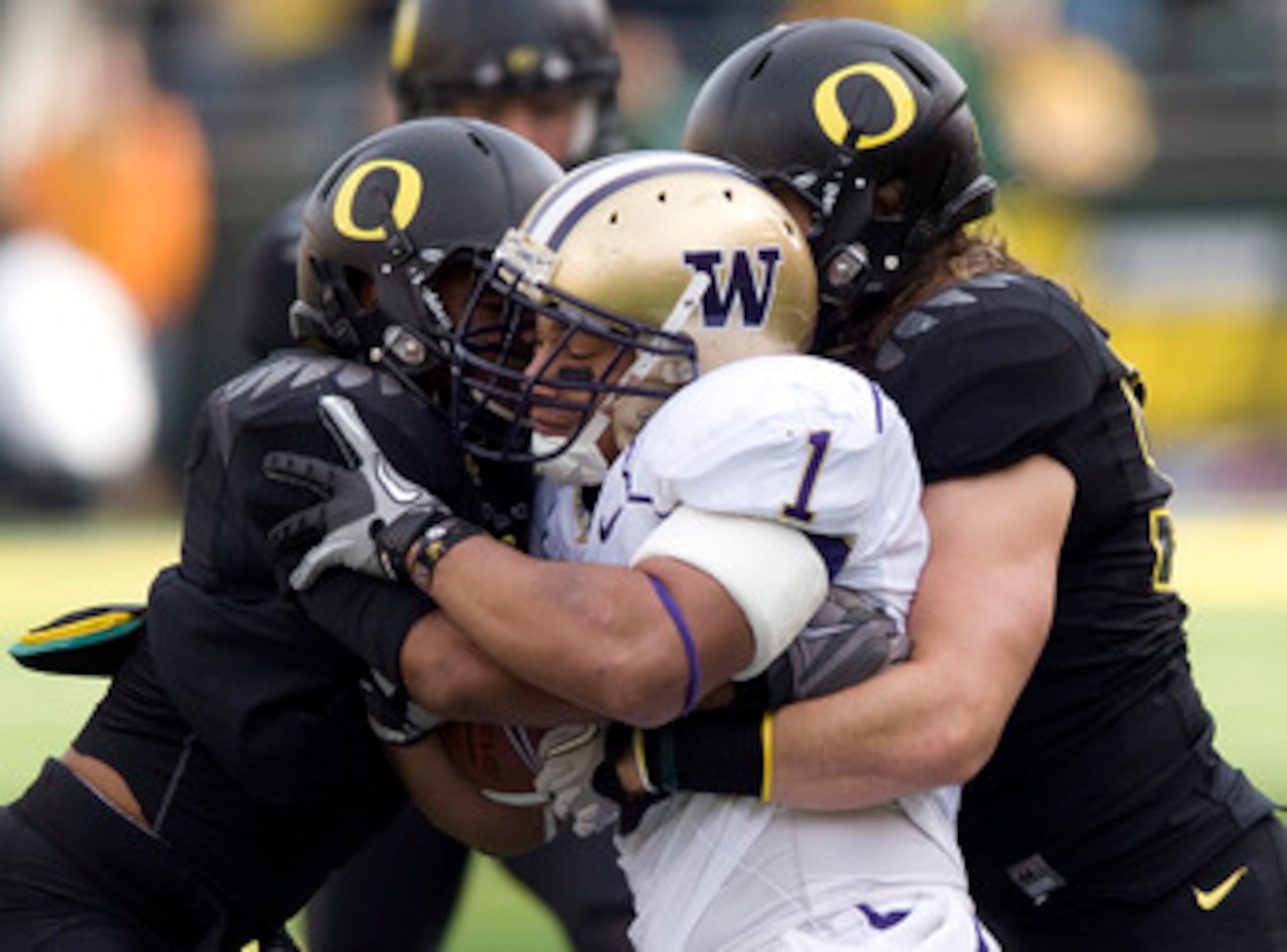 EUGENE, OR - NOVEMBER 6: Linebackers Spencer Paysinger #35 and Clay Matthews #55 of the Oregon Ducks tackle running back Chris Polk #1 of the Washington Huskies in the first quarter of the game at Autzen Stadium on November 6, 2010 in Eugene, Oregon. The