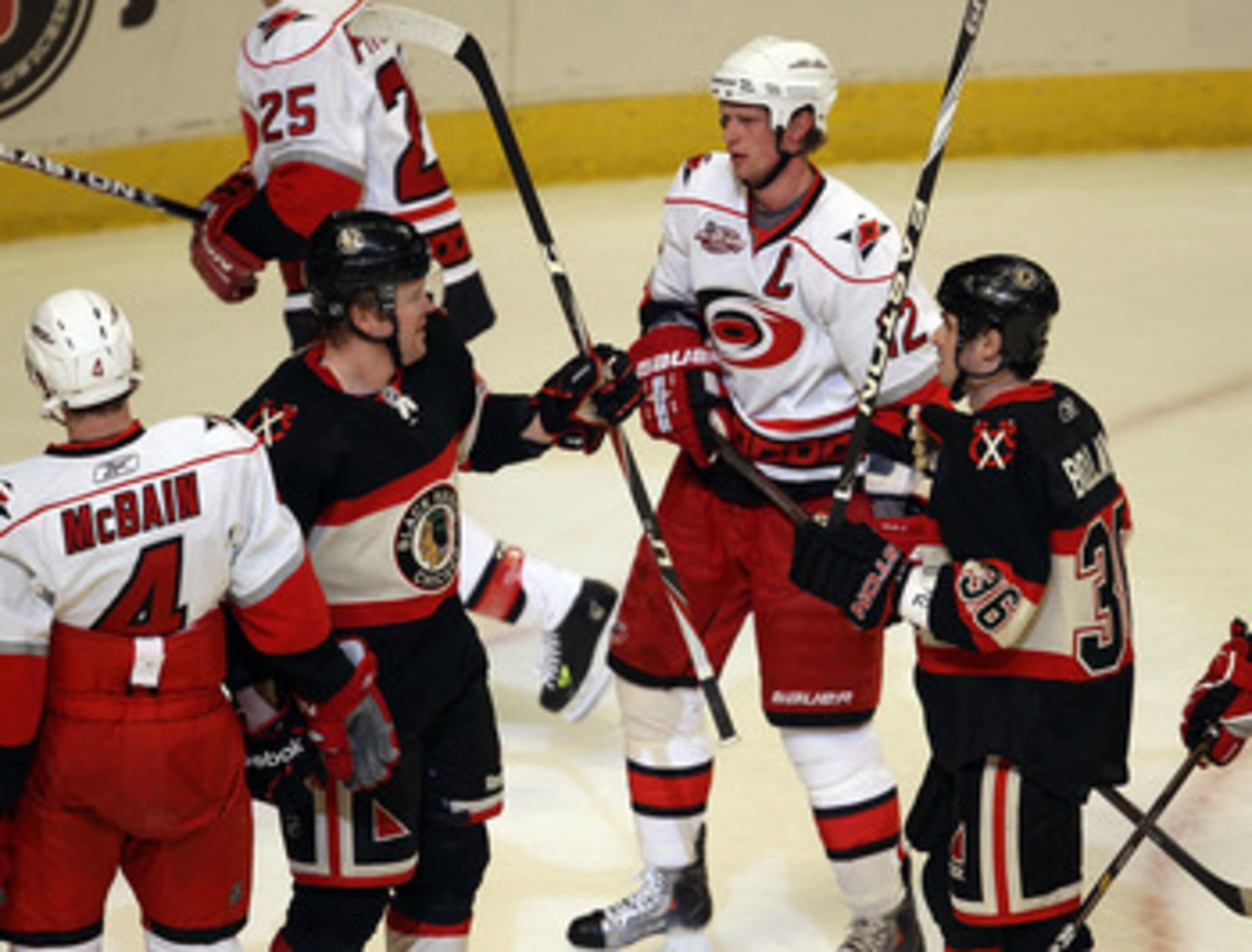 CHICAGO, IL - MARCH 04: Bryan Bickell #29 and Dave Bolland #36 of the Chicago Blackhawks celebrate Bickell's 1st period goal next to Jamie McBain #4 and Eric Staal #12 of the Carolina Hurricanes at the United Center on March 4, 2011 in Chicago, Illinois. 