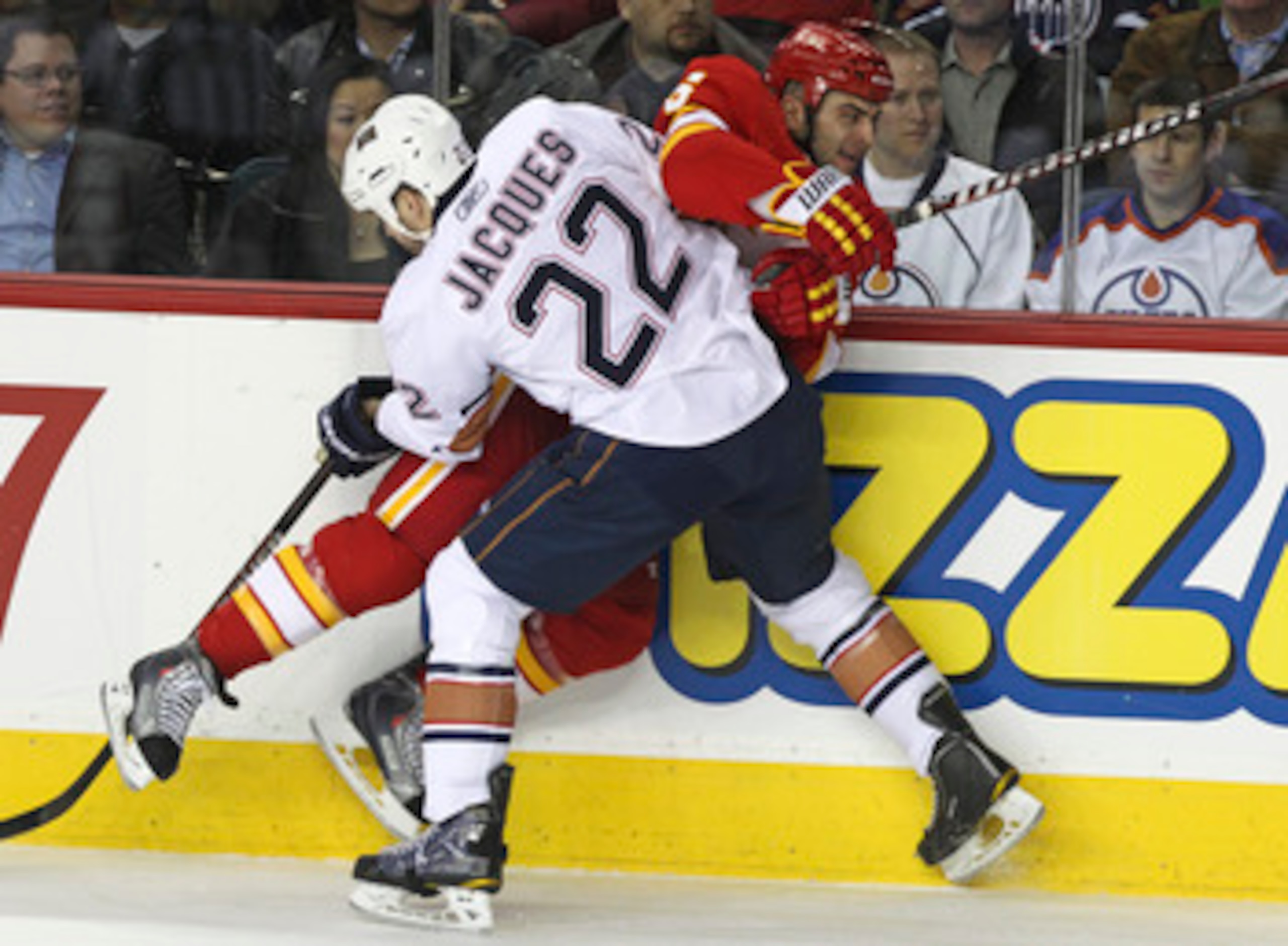 CALGARY, CANADA - APRIL 6: Mark Giordano #5 of the Calgary Flames is pinned against the boards by Jean-Francois Jacques #22 of the Edmonton Oilers in first period NHL action on April 6, 2011 at the Scotiabank Saddledome in Calgary, Alberta, Canada. (Photo