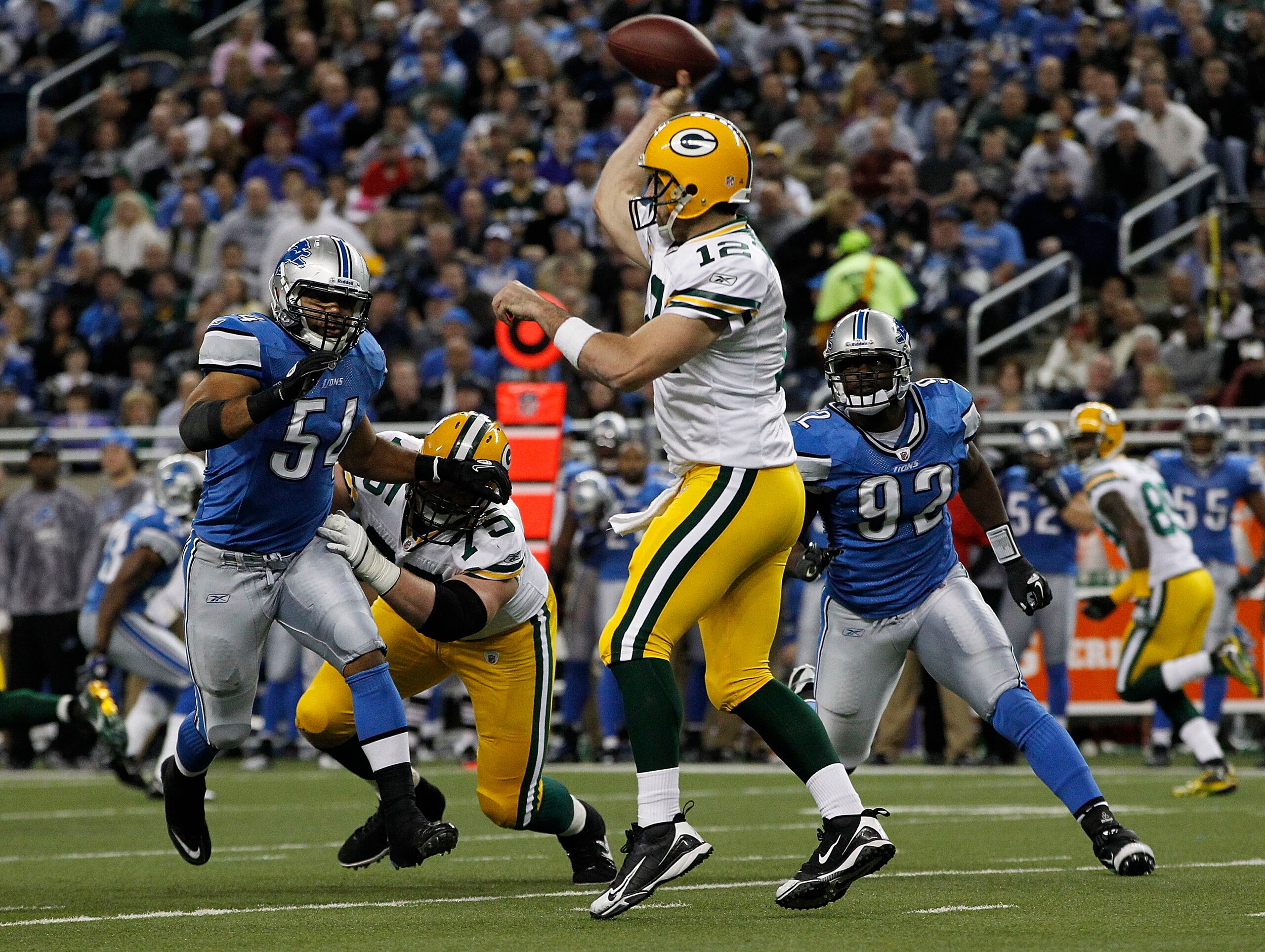 DETROIT - DECEMBER 12: Aaron Rogers #12 of the Green Bay Packers drops back to pass as DeAndre Levy #54 and Cliff Avrill #92 of the Detroit Lions rush the passer during the second quarter of the game against the Detroit Lions at Ford Field on December 12, DETROIT - DECEMBER 12: Aaron Rogers #12 of the Green Bay Packers drops back to pass as DeAndre Levy #54 and Cliff Avrill #92 of the Detroit Lions rush the passer during the second quarter of the game against the Detroit Lions at Ford Field on December 12,