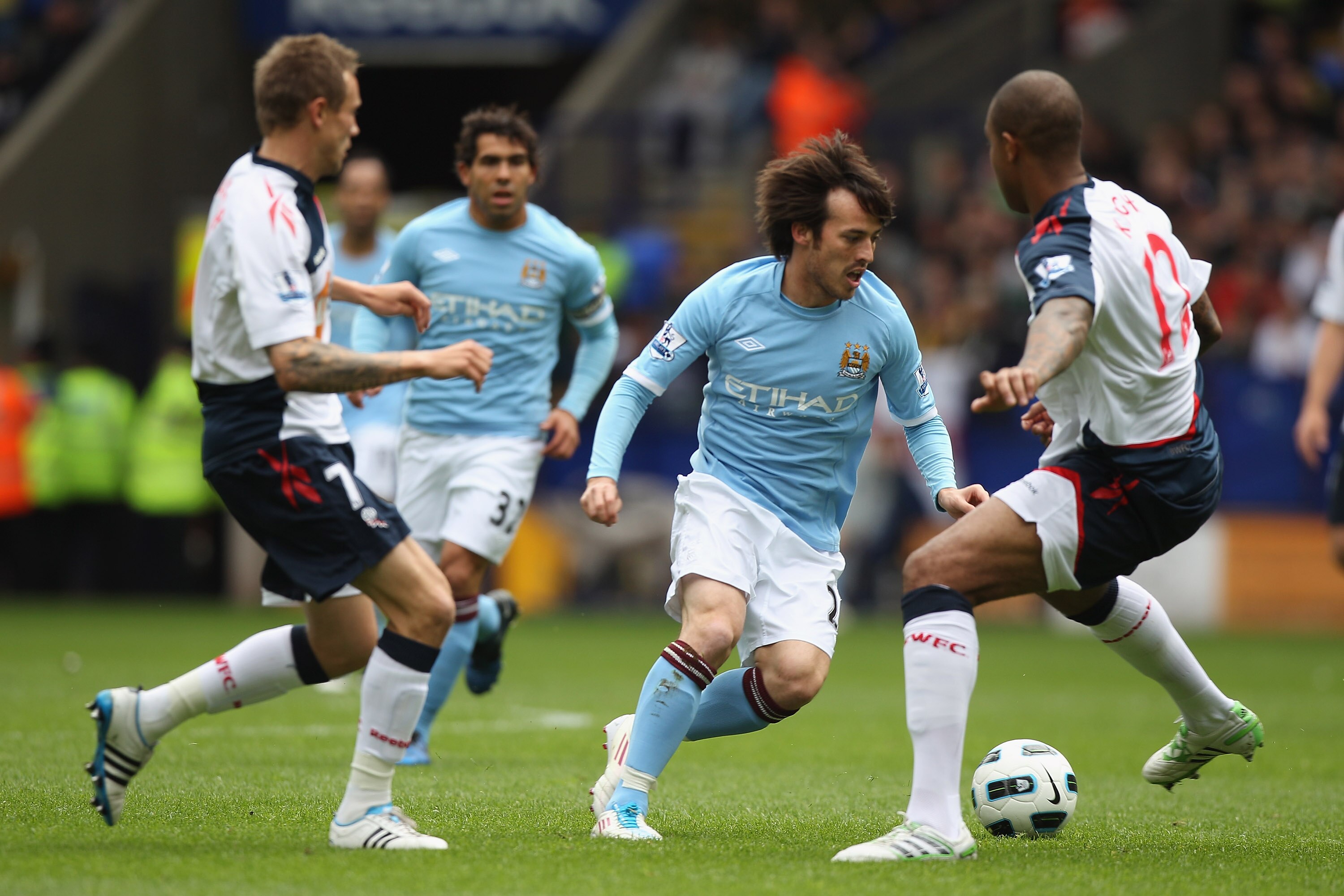 BOLTON, ENGLAND - MAY 22:  David Silva (C) of Manchester City takes on Matt Taylor (L) and Zat Knight (R) during the Barclays Premier League match between  Bolton Wanderers and Manchester City at the Reebok Stadium on May 22, 2011 in Bolton, England.  (Ph