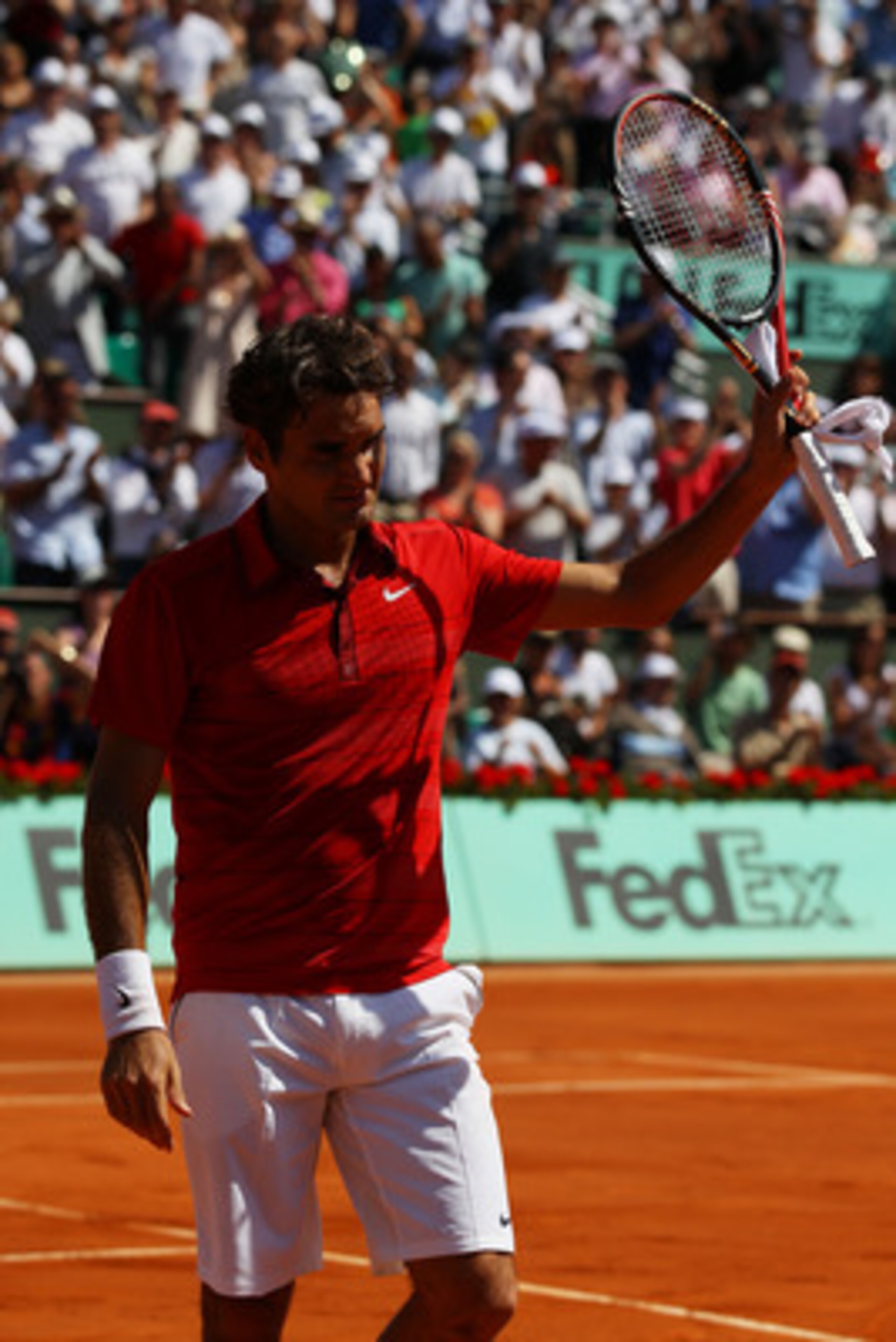 PARIS, FRANCE - MAY 29:  Roger Federer of Switzerland salutes the crowd as he celebrates match point during the men's singles round four match between Stanislas Wawrinka of Switzerland and Roger Federer of Switzerland on day eight of the French Open at Ro