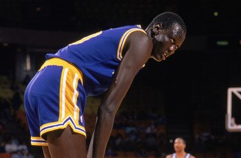 1988:  Manute Bol #10 of the Golden State Warriors rests on the court during an NBA game in the 1988-89 season. NOTE TO USER: User expressly acknowledges and agrees that, by downloading and/or using this Photograph, User is consenting to the terms and con