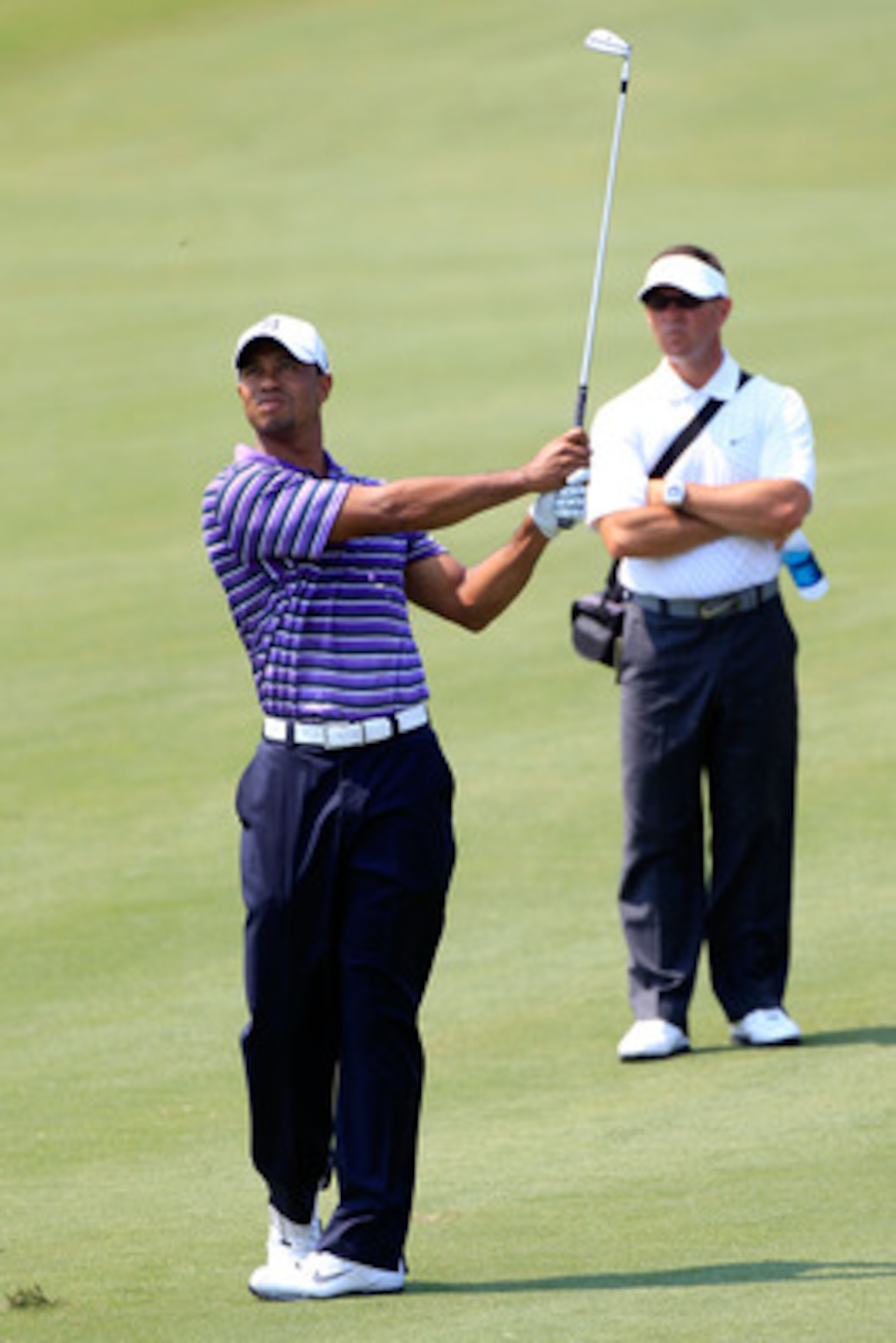 PONTE VEDRA BEACH, FL - MAY 10:  Tiger Woods (L) hits a shot as his instructor Sean Foley (R) looks on during a practice round prior to the start of THE PLAYERS Championship held at THE PLAYERS Stadium course at TPC Sawgrass on May 10, 2011 in Ponte Vedra