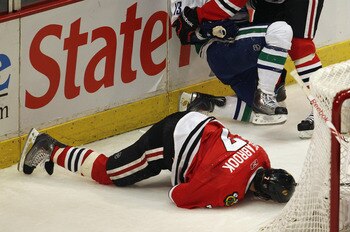 CHICAGO, IL - APRIL 17: Chris Campoli #14 of the Chicago Blackhawks hits Raffi Torres #13 of the Vancouver Canucks after Torres knocked down Brent Seabrook #7 with a hit behind the net in Game Three of the Western Conference Quarterfinals during the 2011