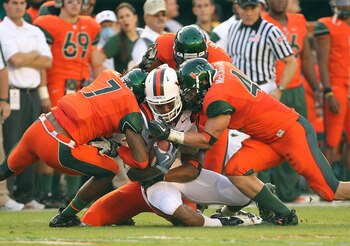 MIAMI - NOVEMBER 20:  Marcus Davis #7 of the Virginia Tech Hokies is hit by Vaughn Telemaque #7 and Colin McCarthy #44 of the Miami Hurricanes at Sun Life Stadium on November 20, 2010 in Miami, Florida.  (Photo by Mike Ehrmann/Getty Images)